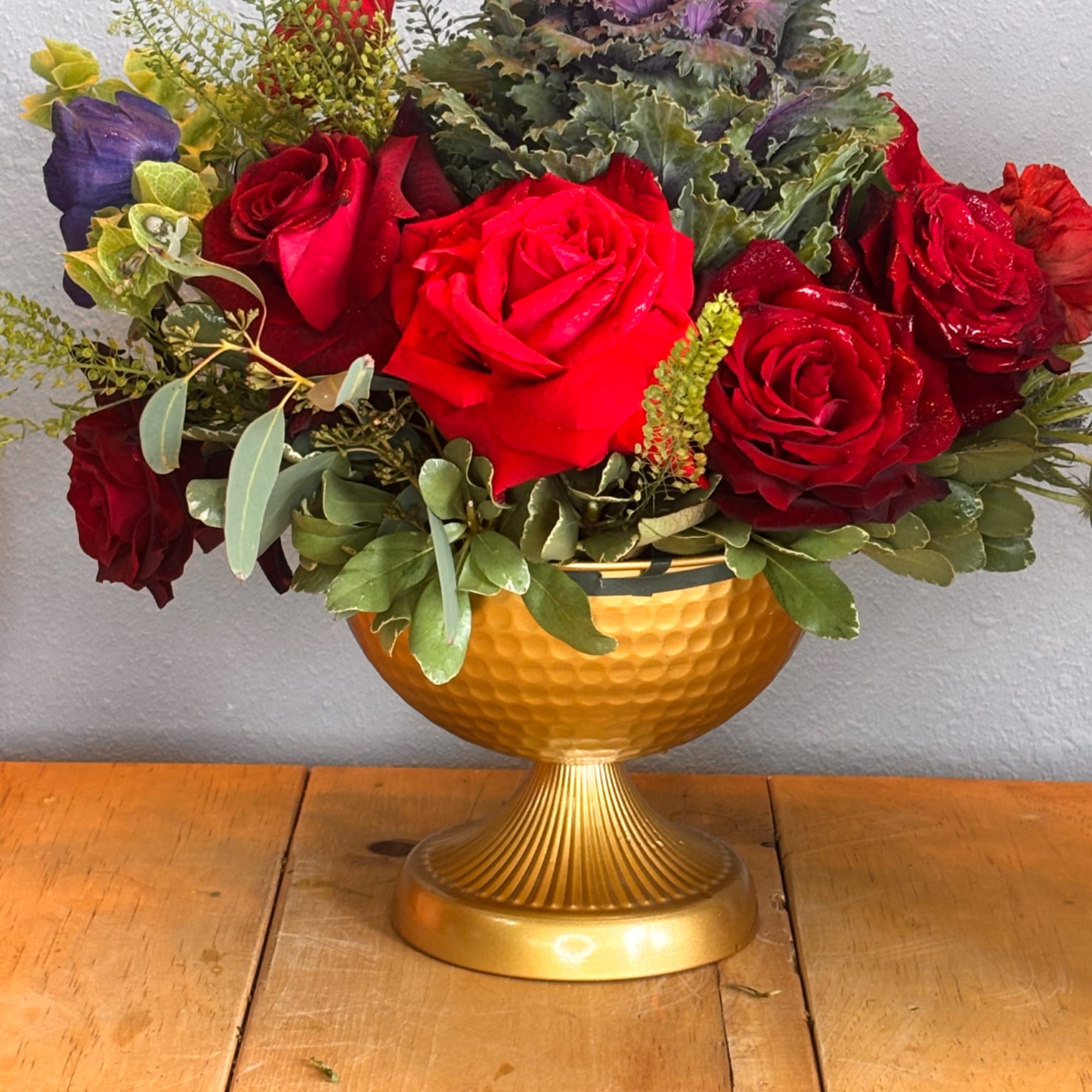 Red rose arrangement in a gold pedestal bowl