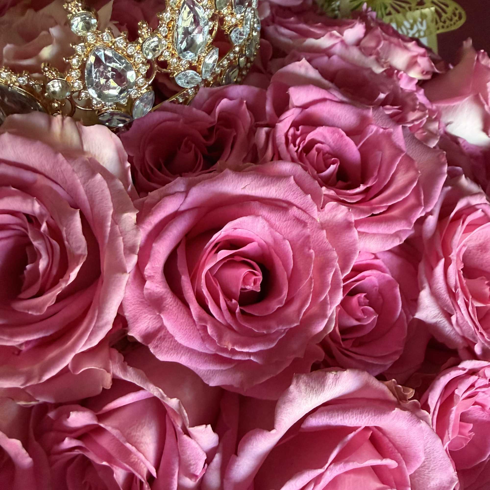 Pink roses arranged with a jeweled crown and butterfly decoration
