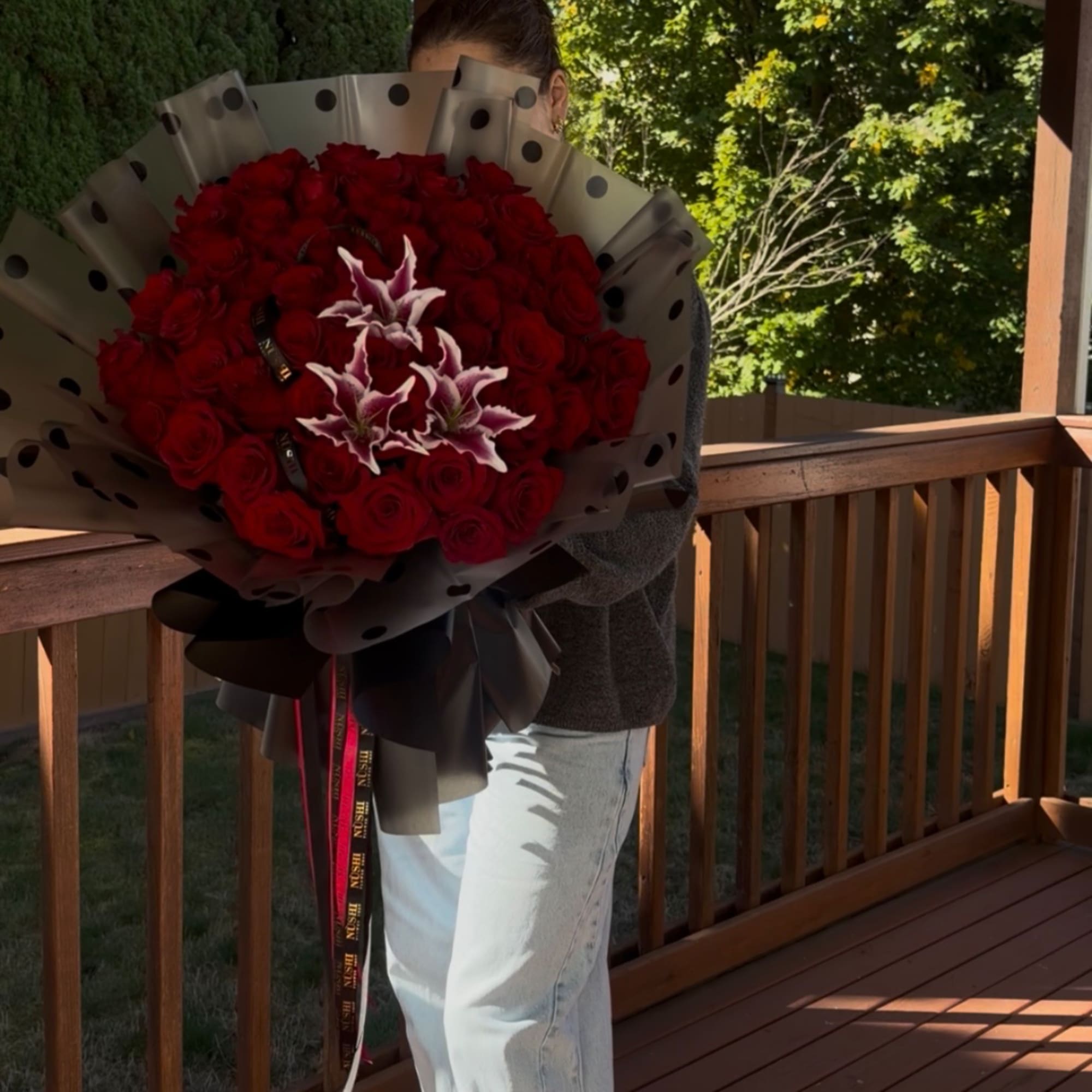 Large bouquet of red roses with white lilies wrapped in black paper