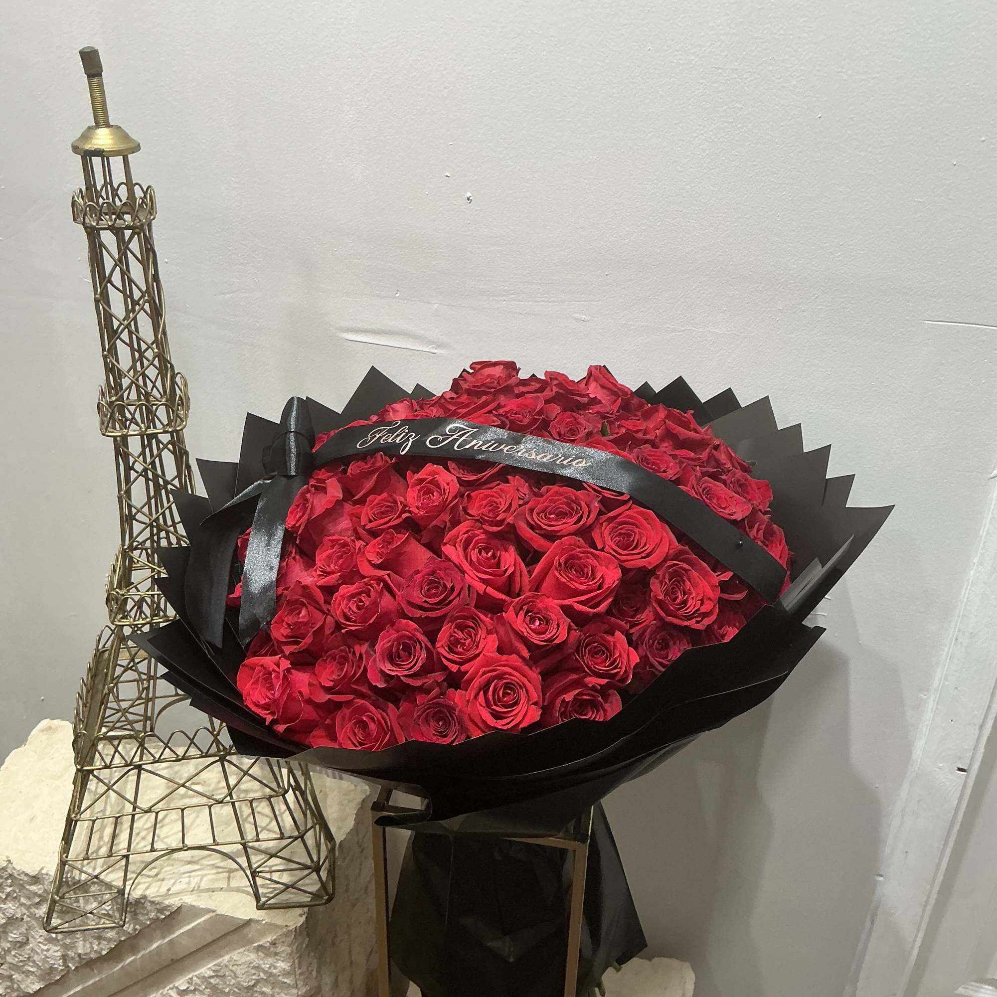 A dense, hand-tied bouquet of vivid red roses makes an immediate, romantic