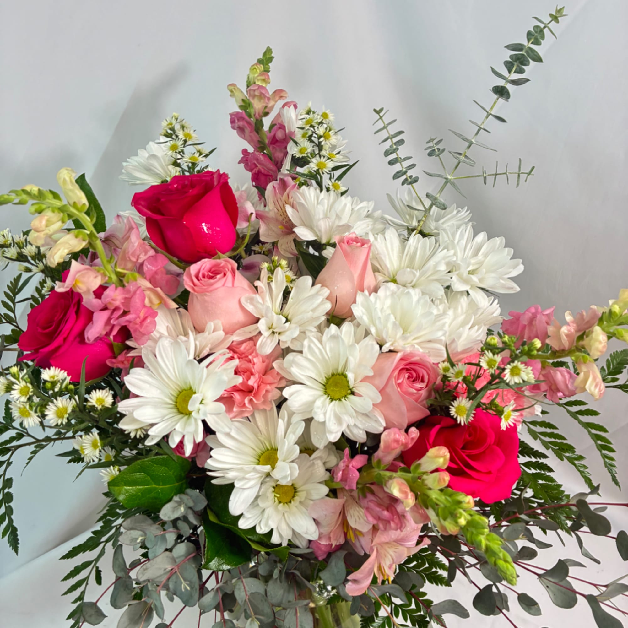Bouquet of pink roses and white daisies with eucalyptus