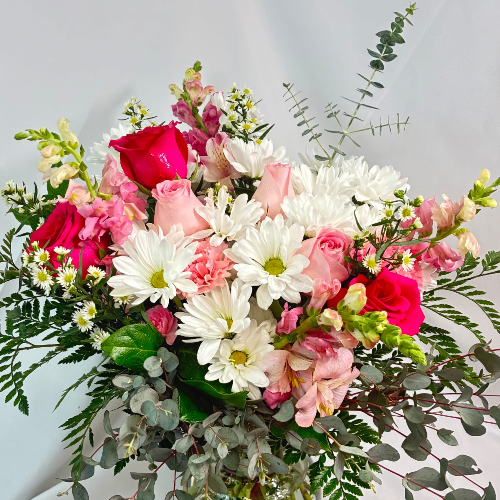 Bouquet of pink roses, white daisies, and mixed blooms with eucalyptus