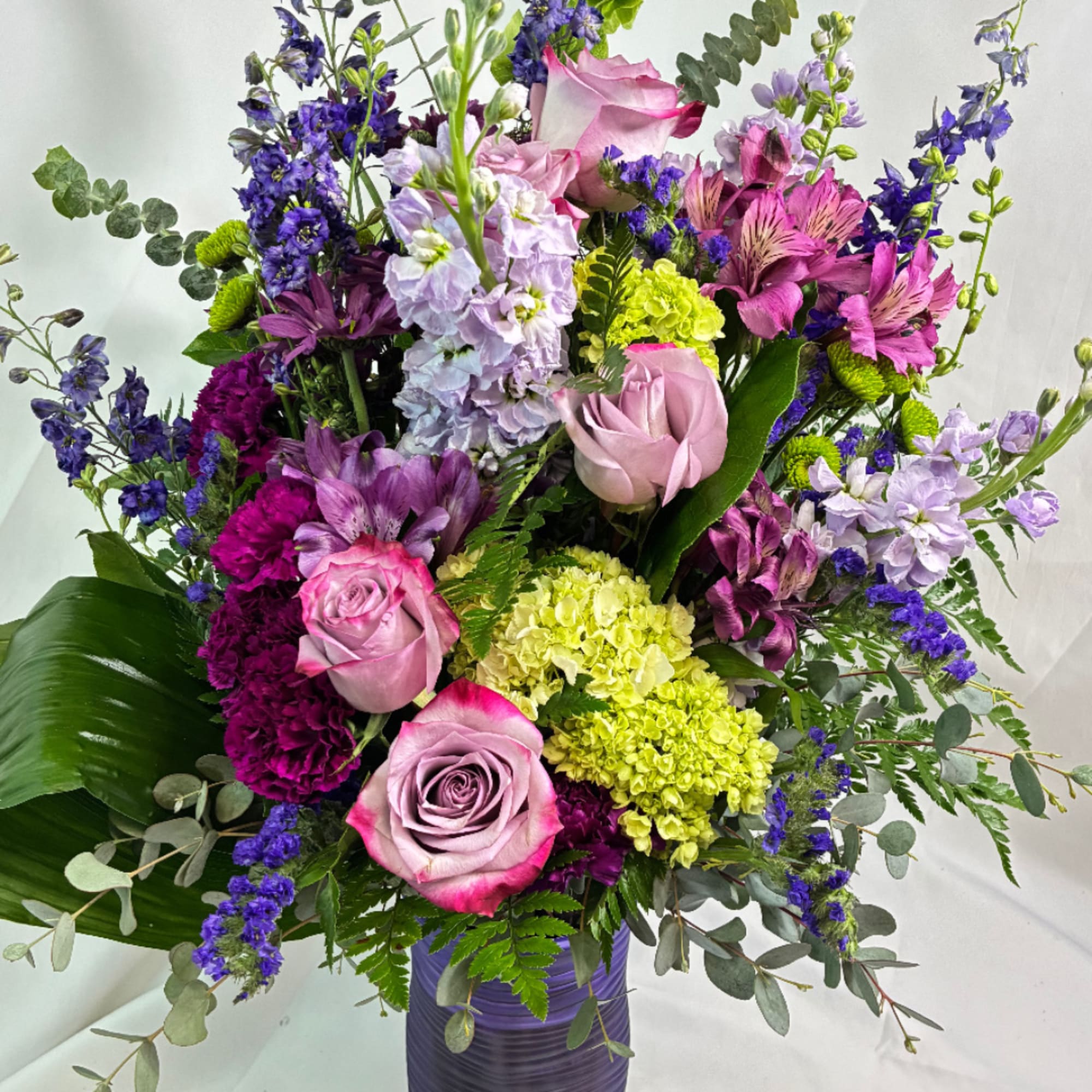 Mixed bouquet of pink roses, purple blooms, and green hydrangeas in a vase, photo 2 of 4