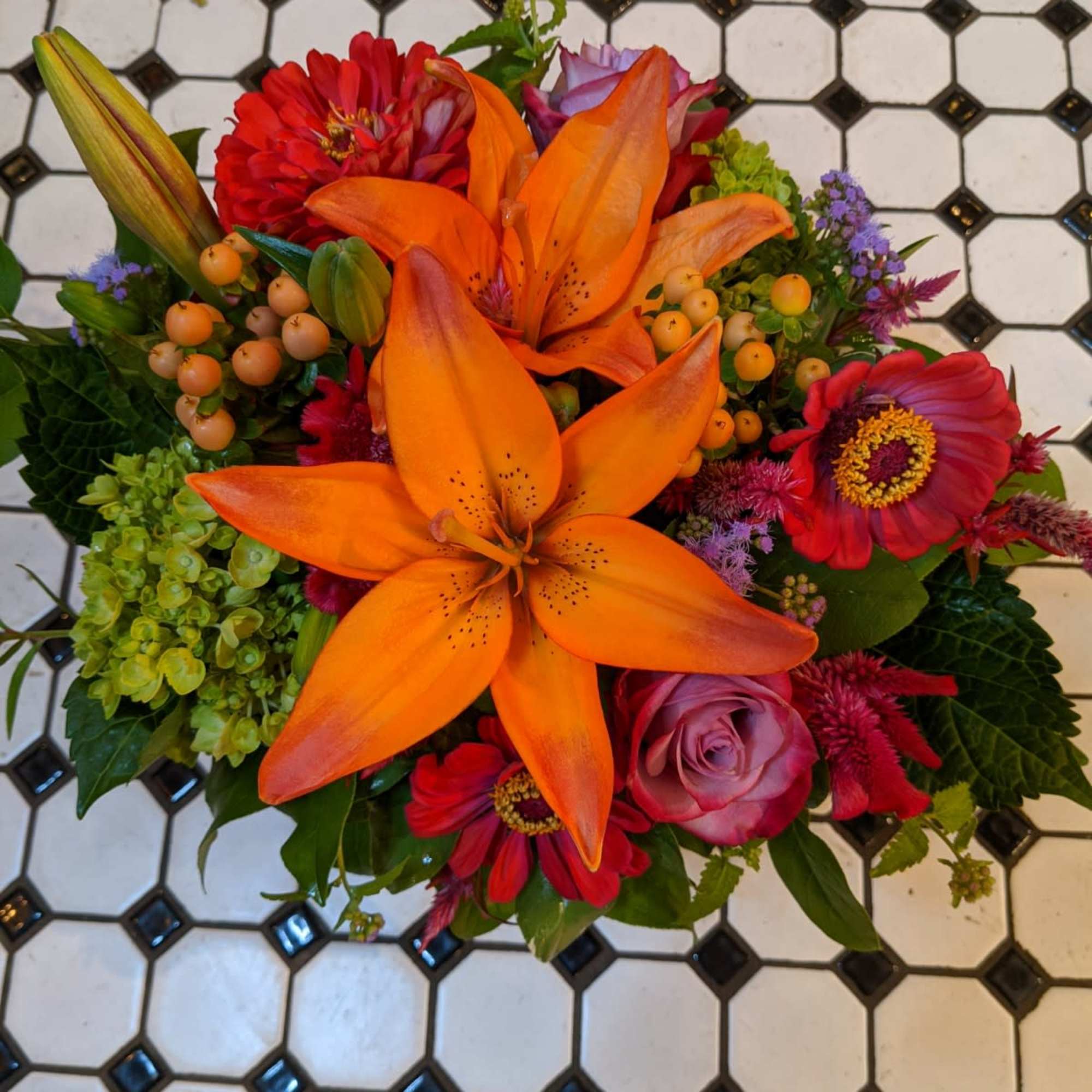 Bright mixed bouquet with orange lilies and red flowers