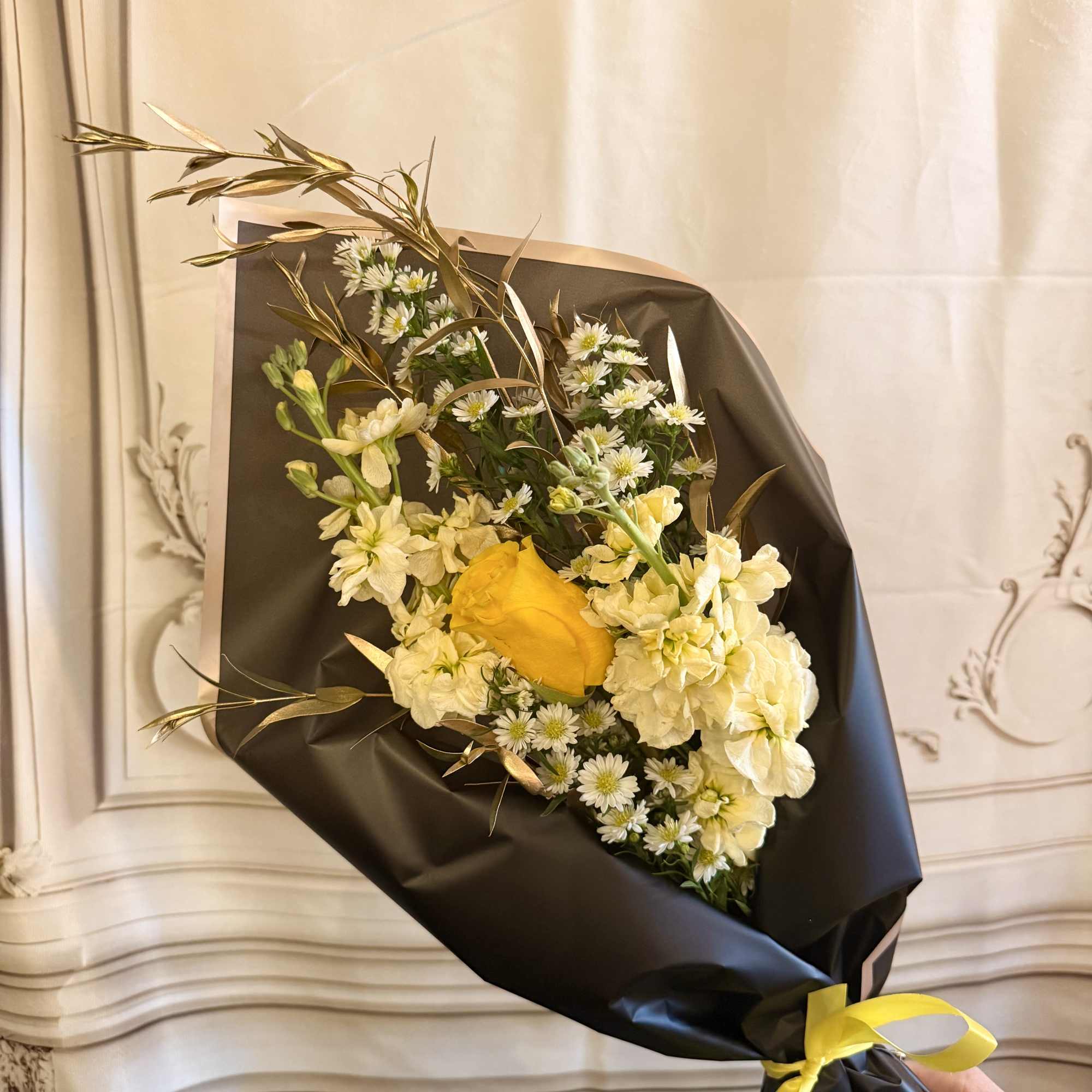 Bouquet of yellow and white flowers wrapped in black paper with a yellow ribbon, photo 2 of 2