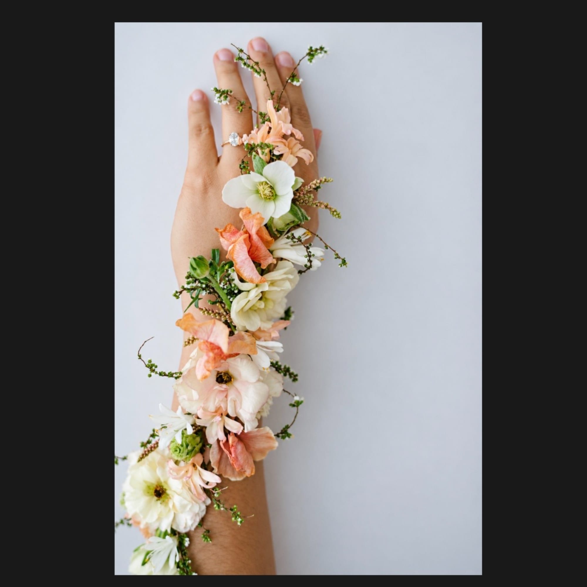 Floral wrist corsage on a hand with white and peach blooms