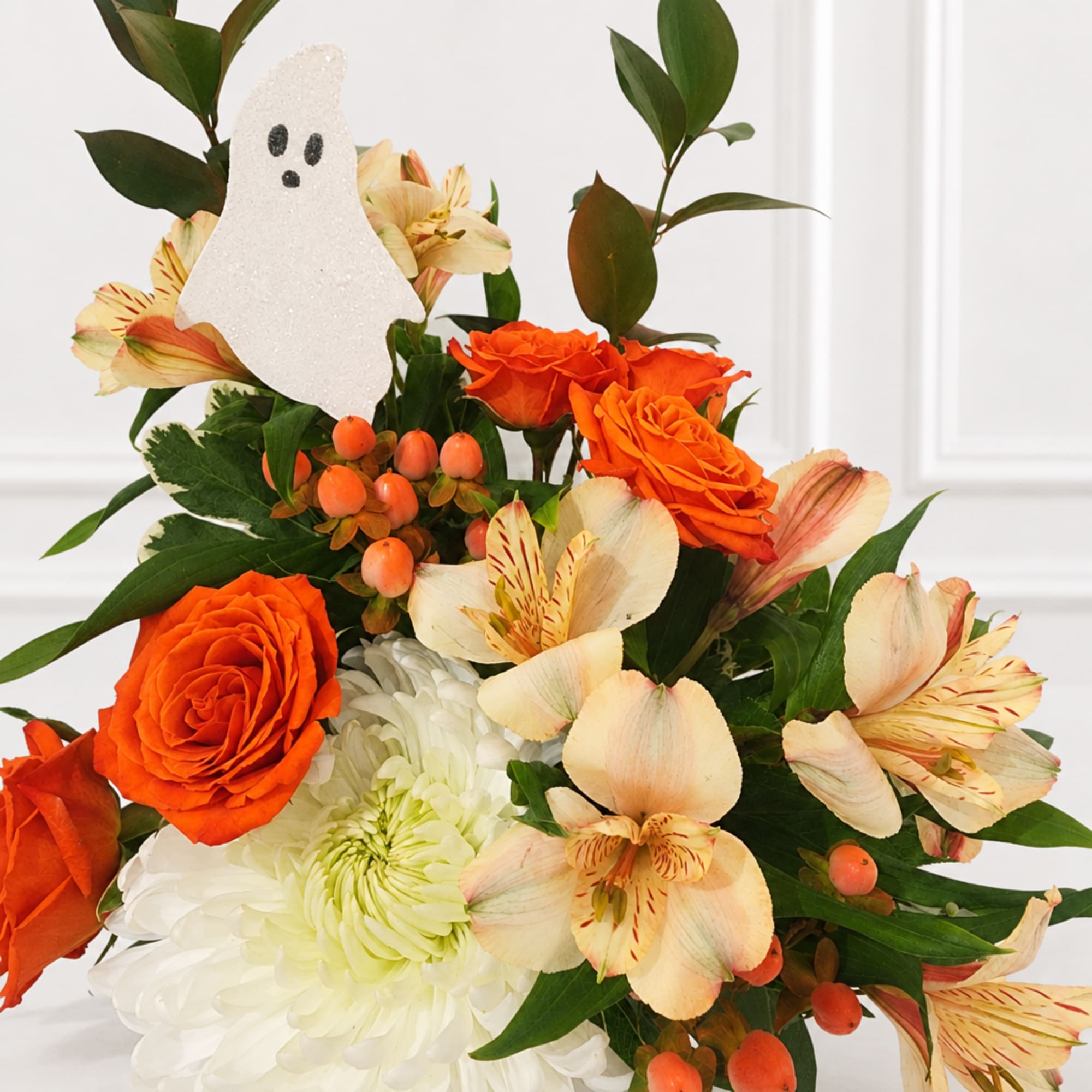 Orange roses and pale alstroemeria with a white chrysanthemum and ghost decoration