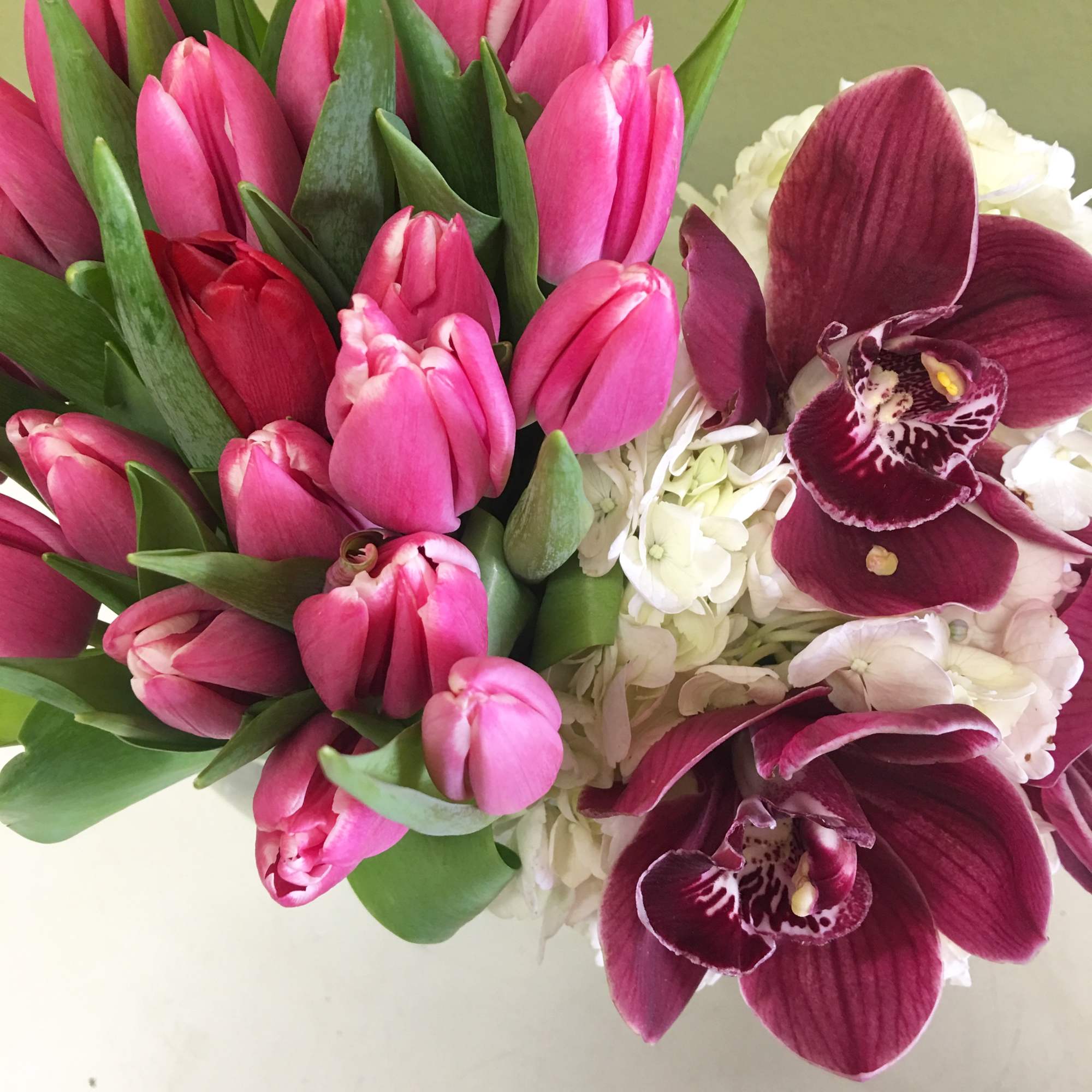 Bouquet of pink tulips and burgundy orchids with white hydrangeas