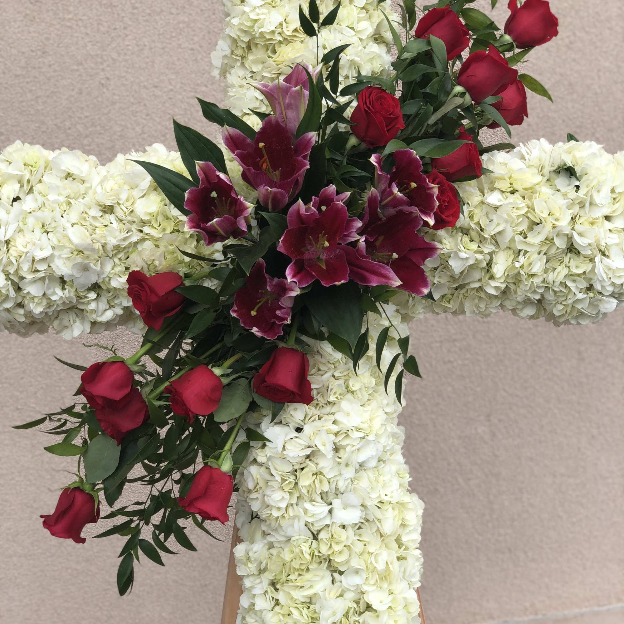 White floral cross with red roses and lilies