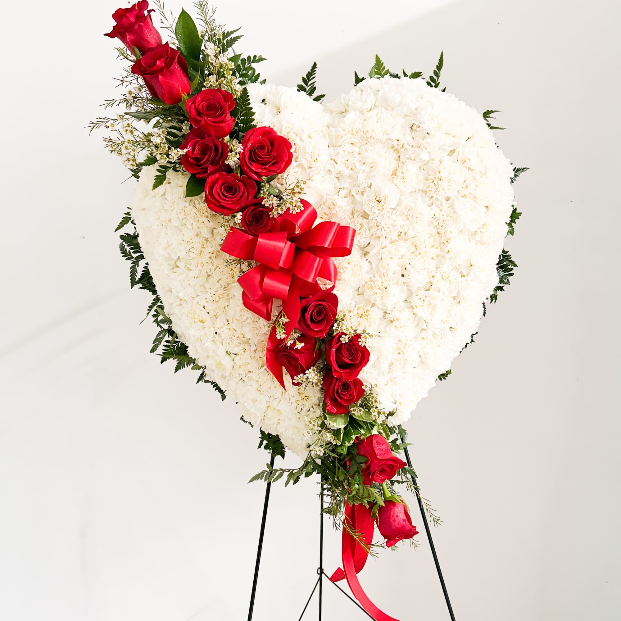 A large heart-shaped standing spray that speaks to the person you're honoring