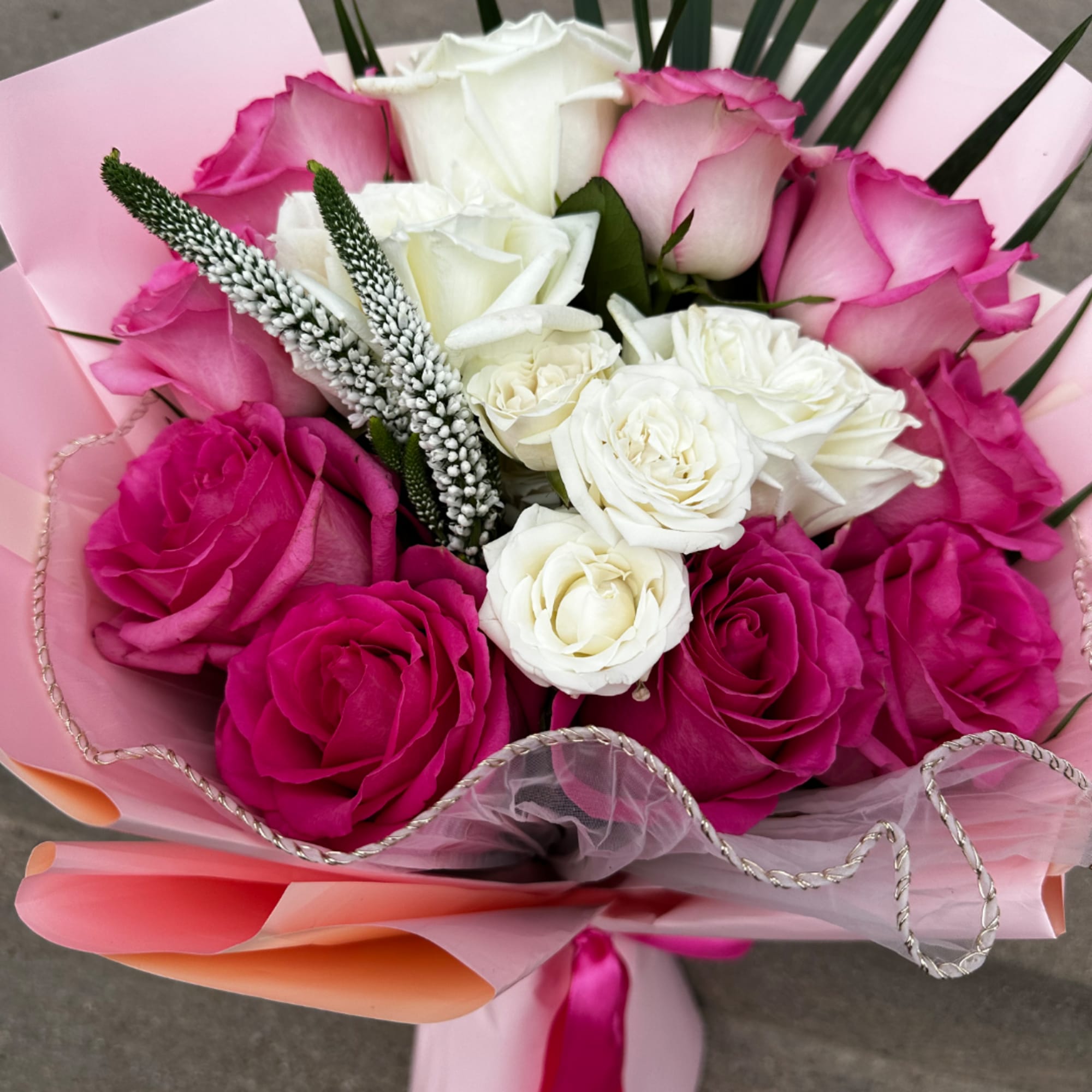 Pink and white rose bouquet wrapped in pastel paper