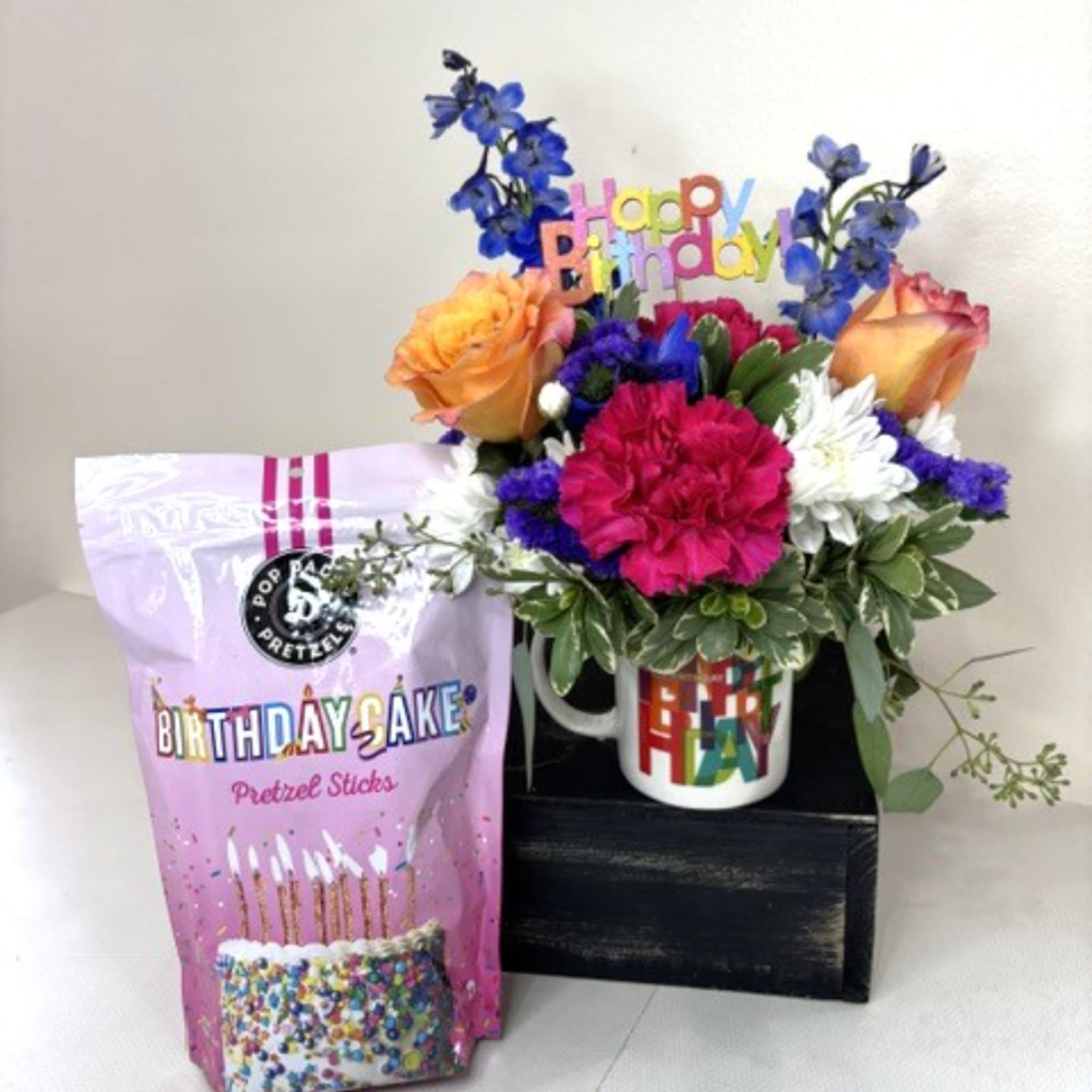 Birthday flower arrangement with roses and carnations, plus a birthday snack bag