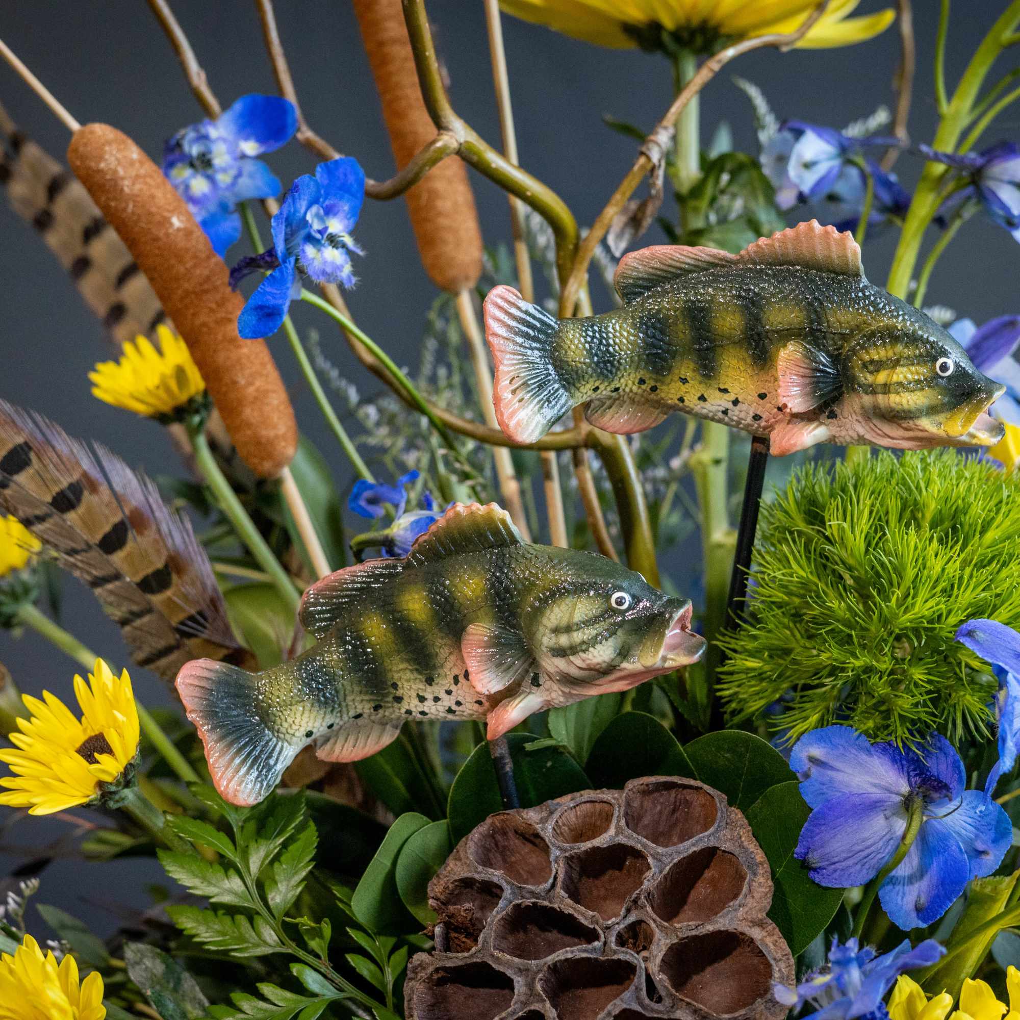 Arrangement with blue and yellow flowers and decorative fish accents