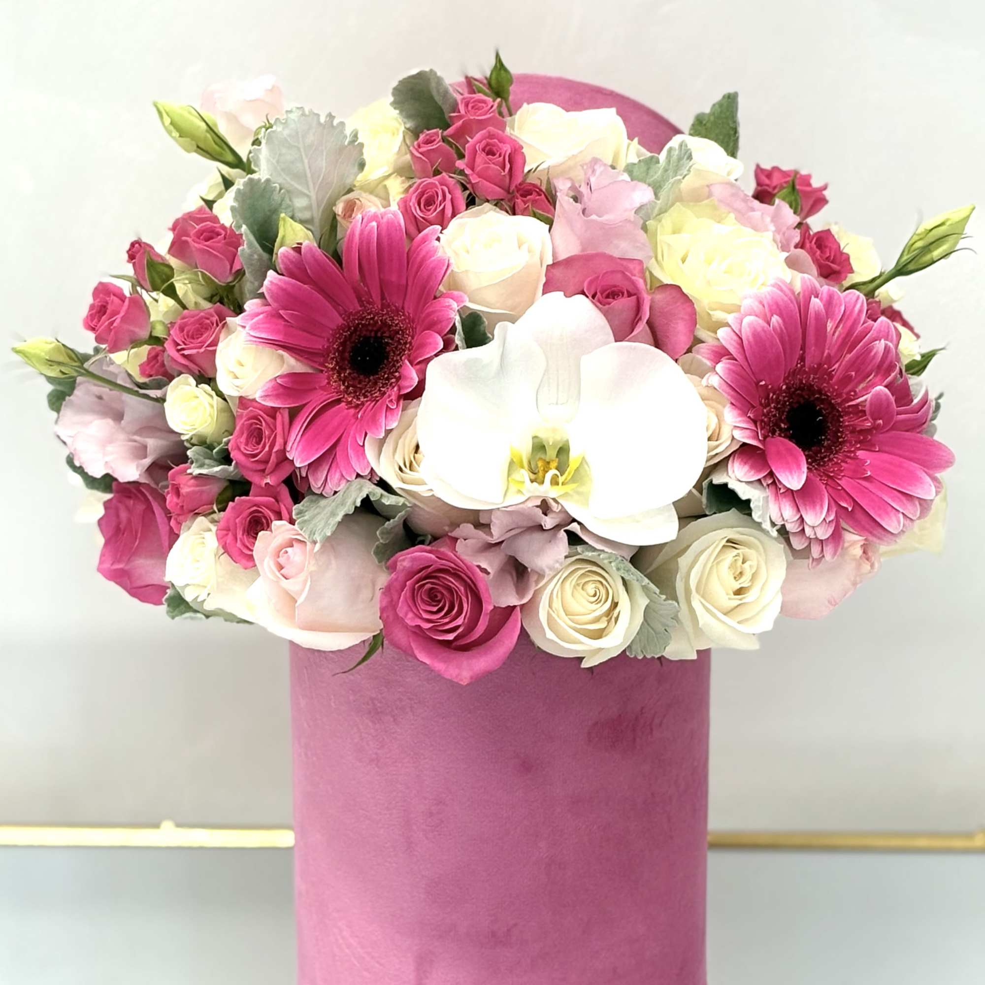 Pink and white bouquet with roses, gerbera daisies, and an orchid in a pink box