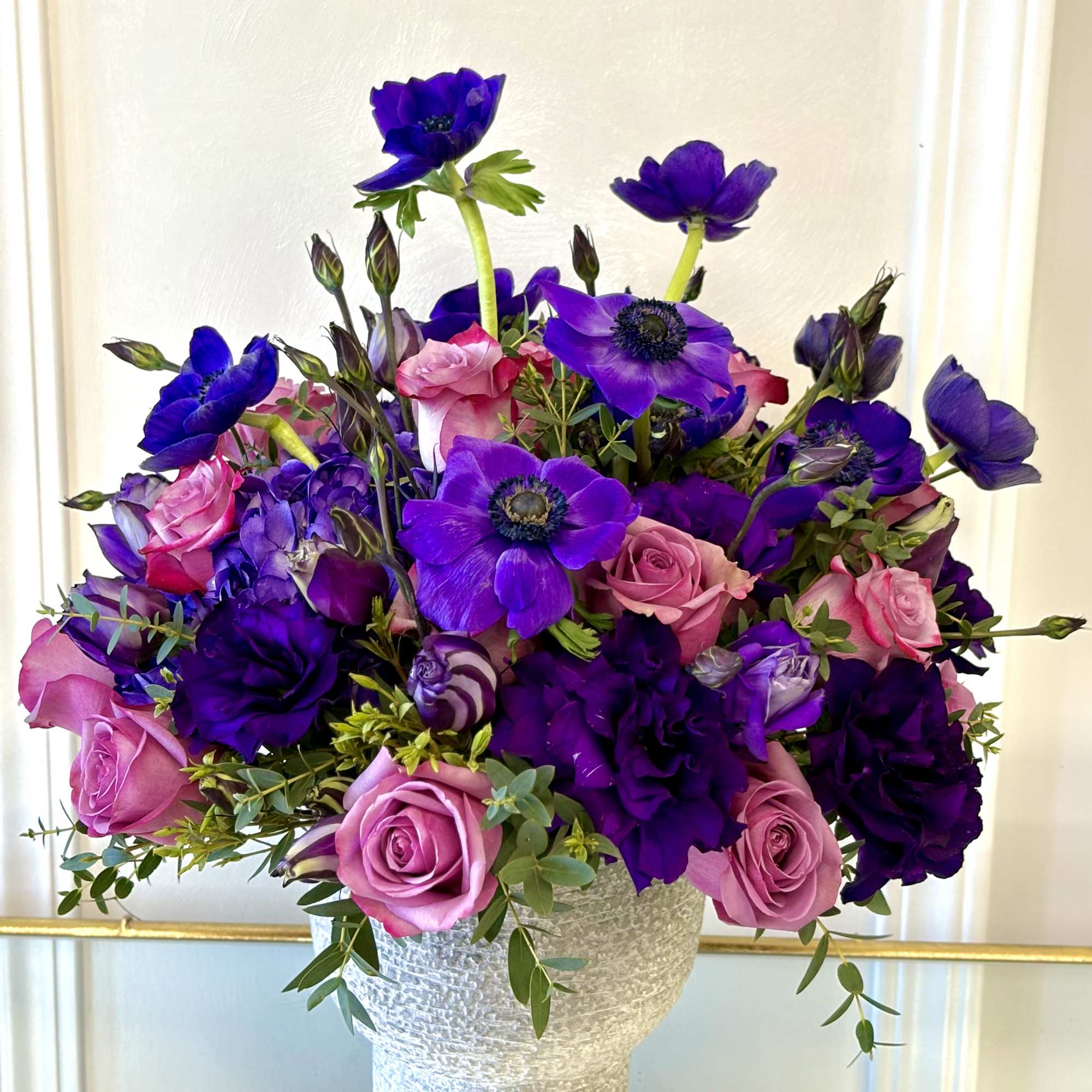 Purple and pink bouquet in a textured silver vase