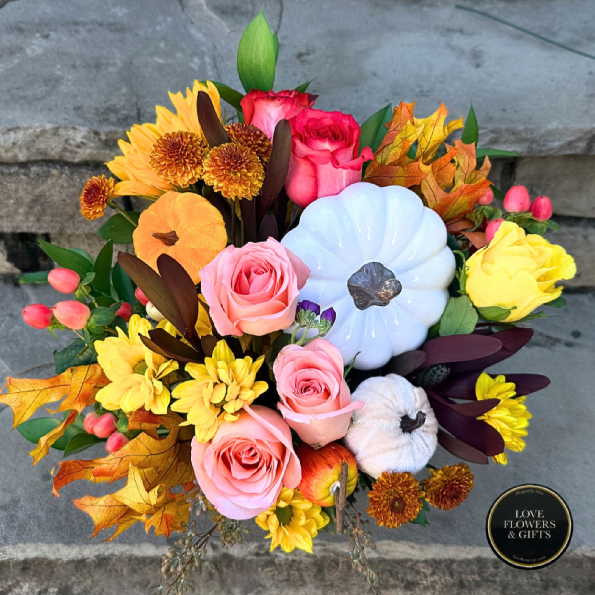 Bouquet with pink and yellow roses, chrysanthemums, and decorative pumpkins