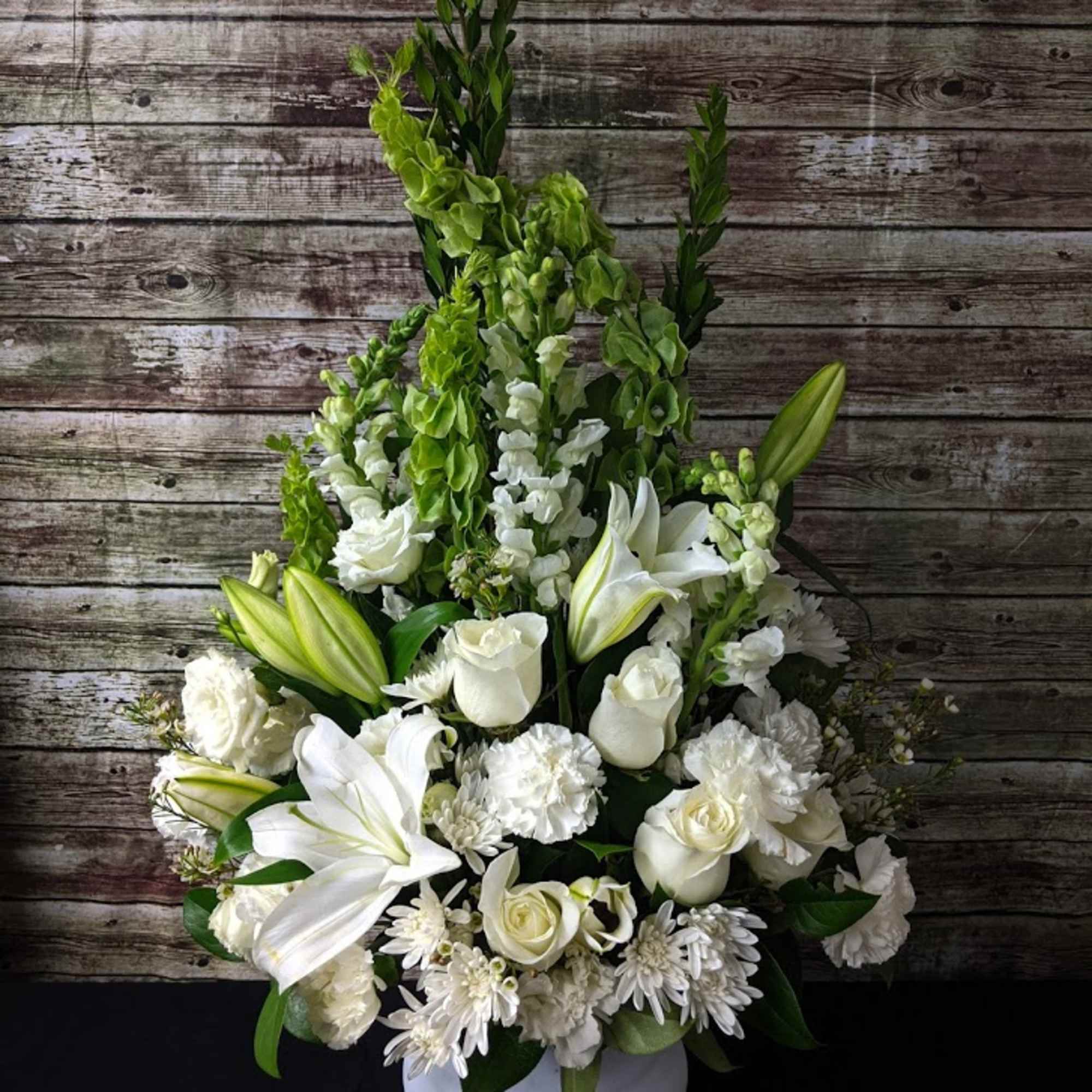 White floral arrangement in a white pedestal vase