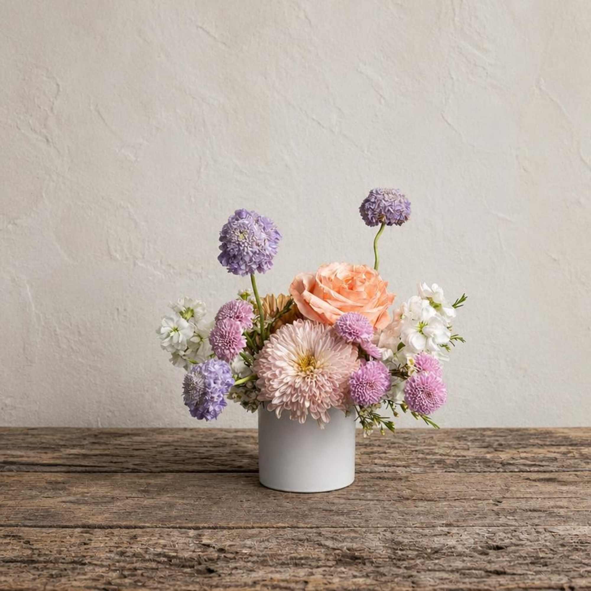 Small pastel flower arrangement in a white vase
