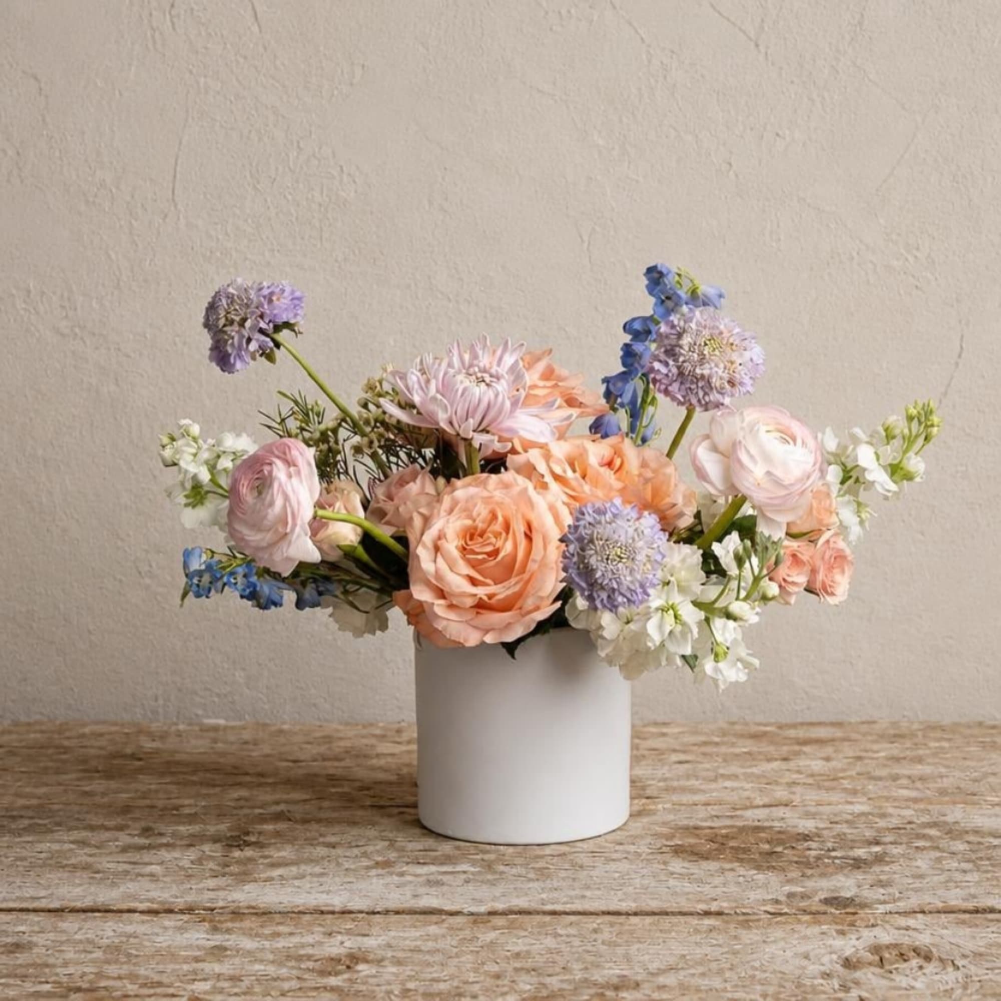 Pastel flower arrangement in a white cylindrical vase