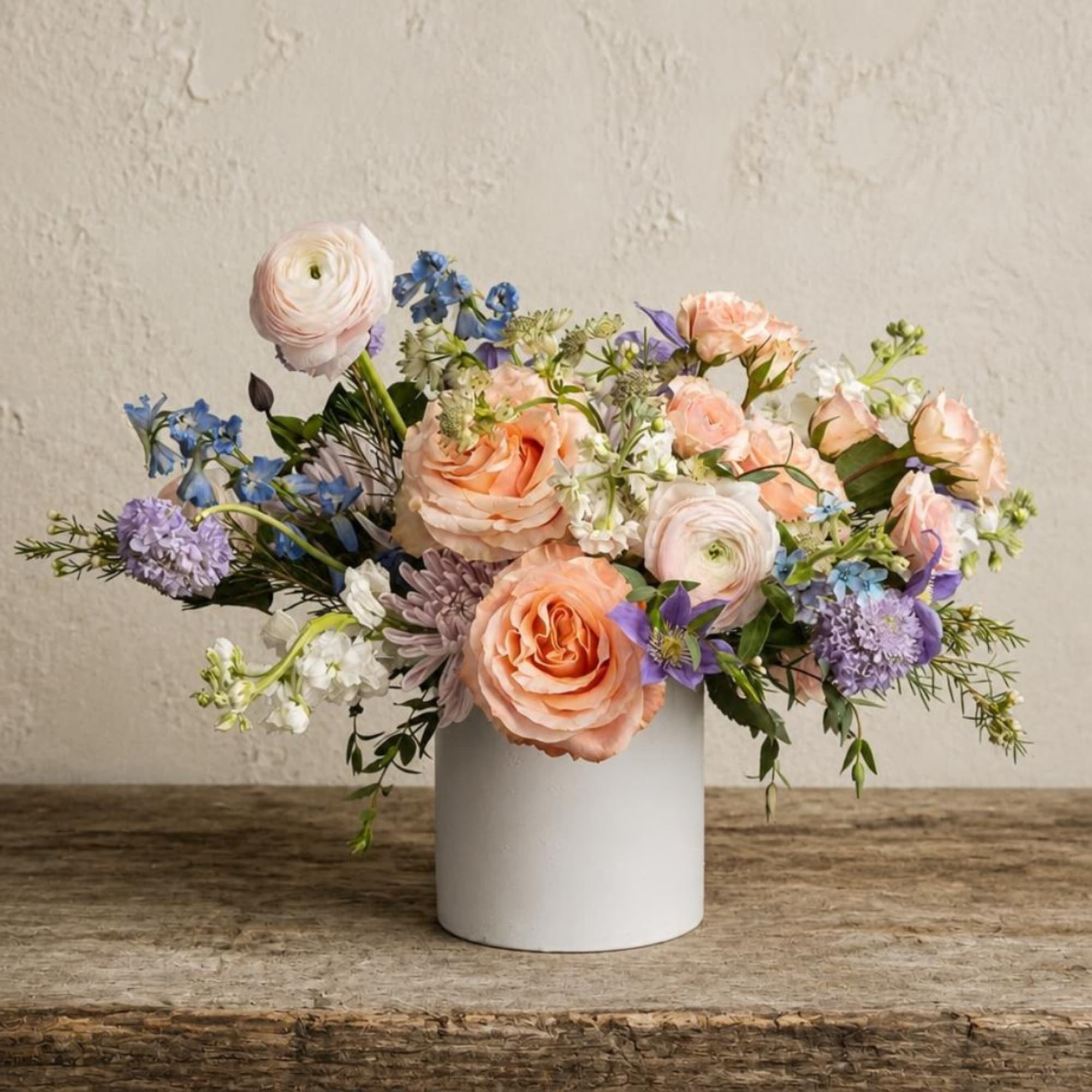 Pastel flower arrangement in a white cylindrical vase