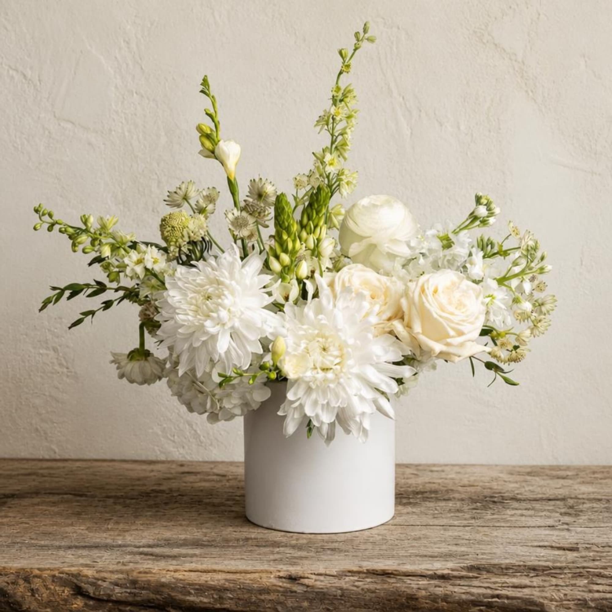 White floral arrangement in a white cylindrical vase