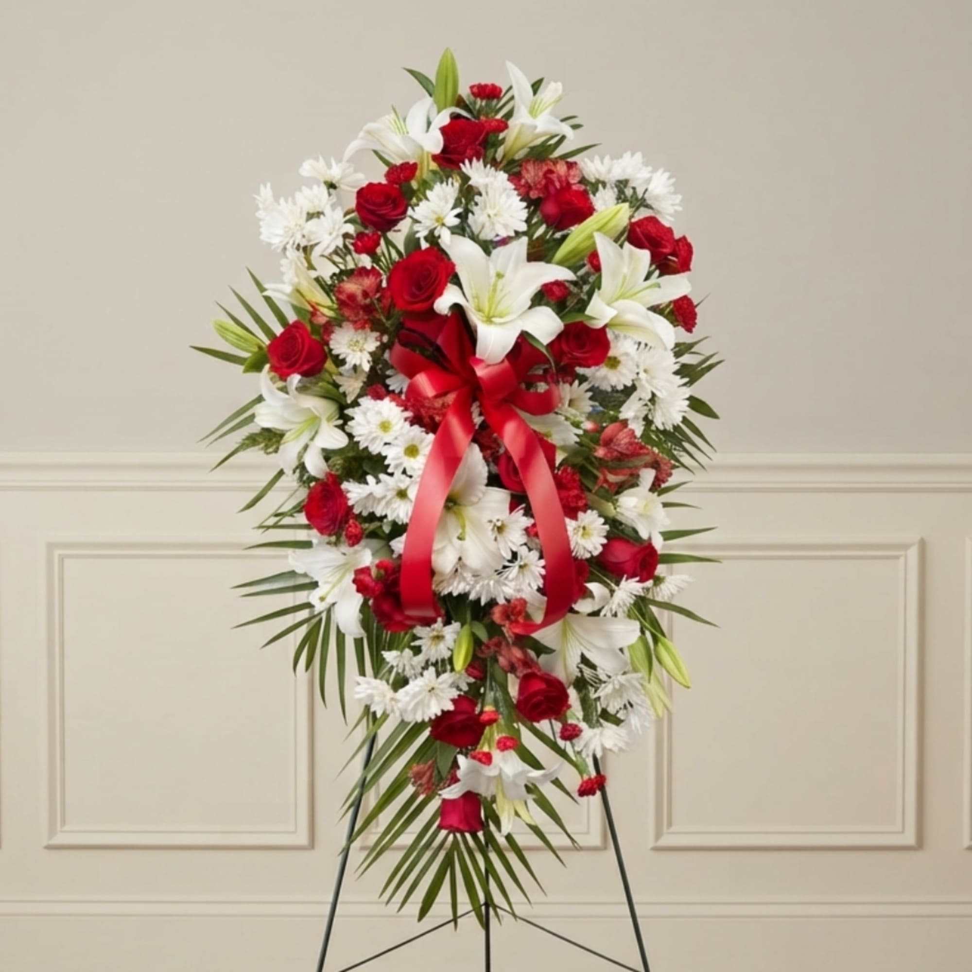 Red and white floral standing spray with a red ribbon on an easel