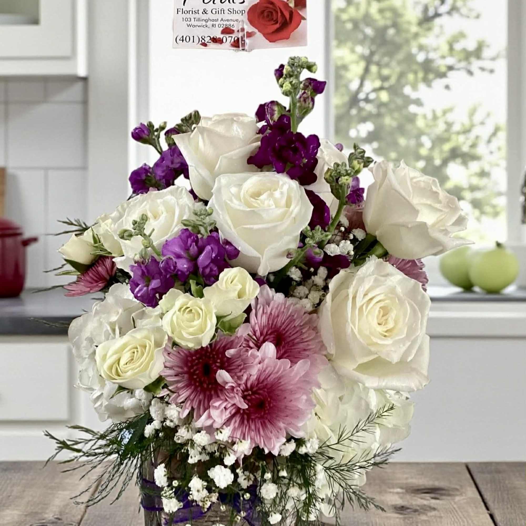 White and purple rose bouquet in a glass vase