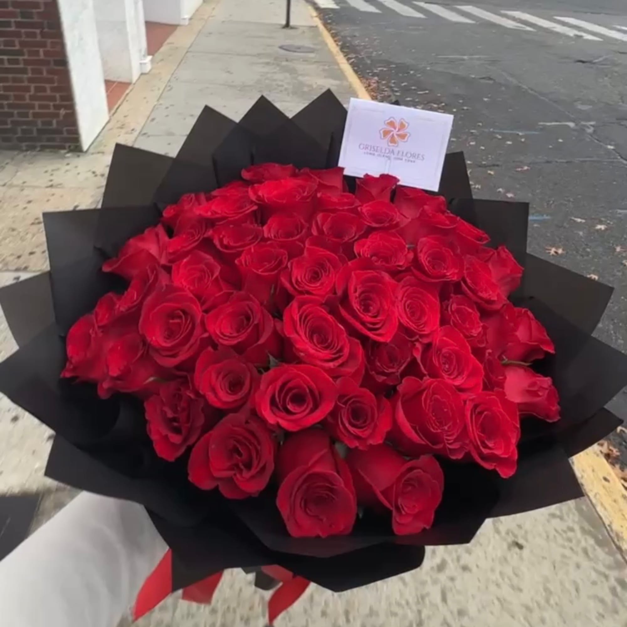 Large bouquet of red roses wrapped in black paper, photo 3 of 4