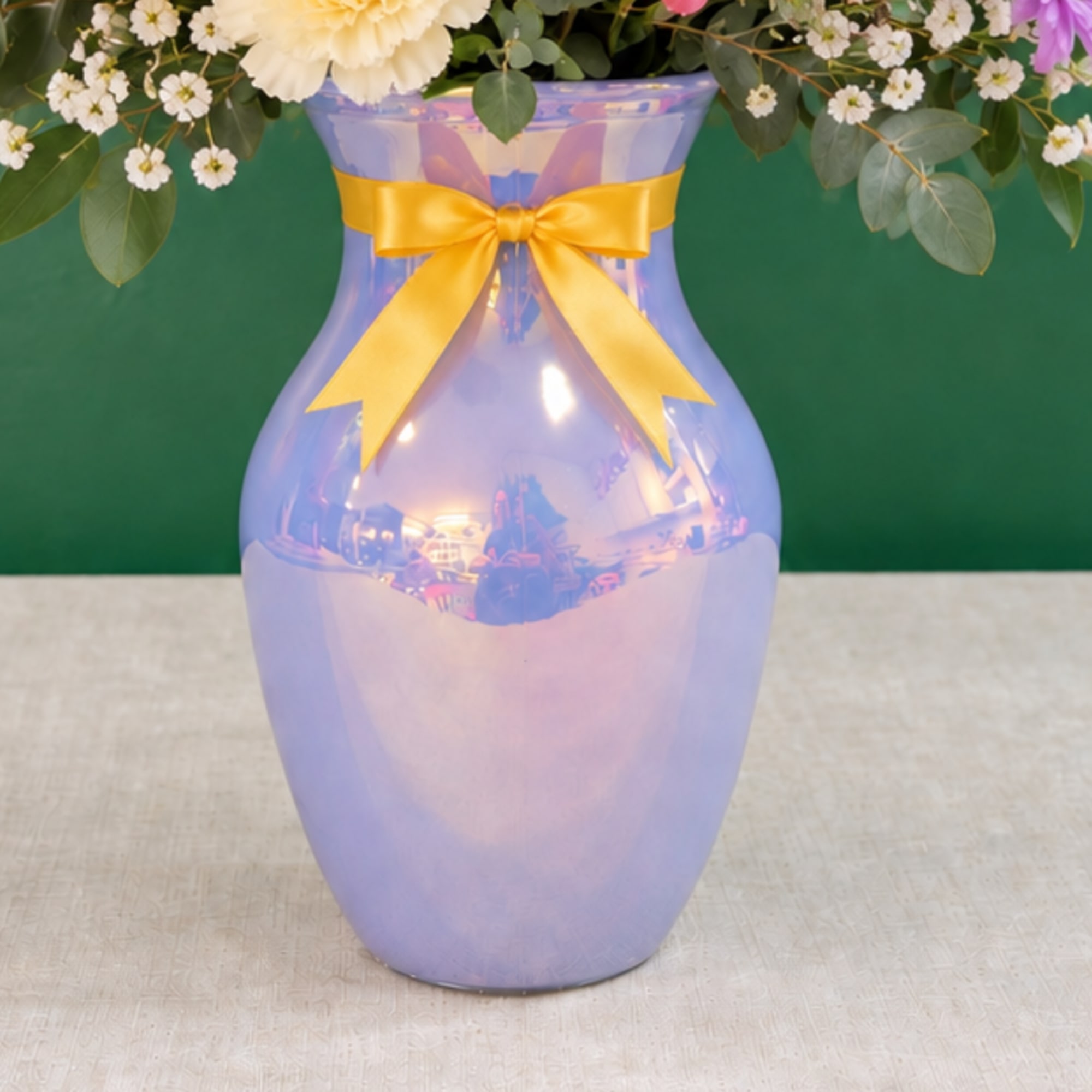 Lavender vase with a yellow ribbon and flowers arranged at the top