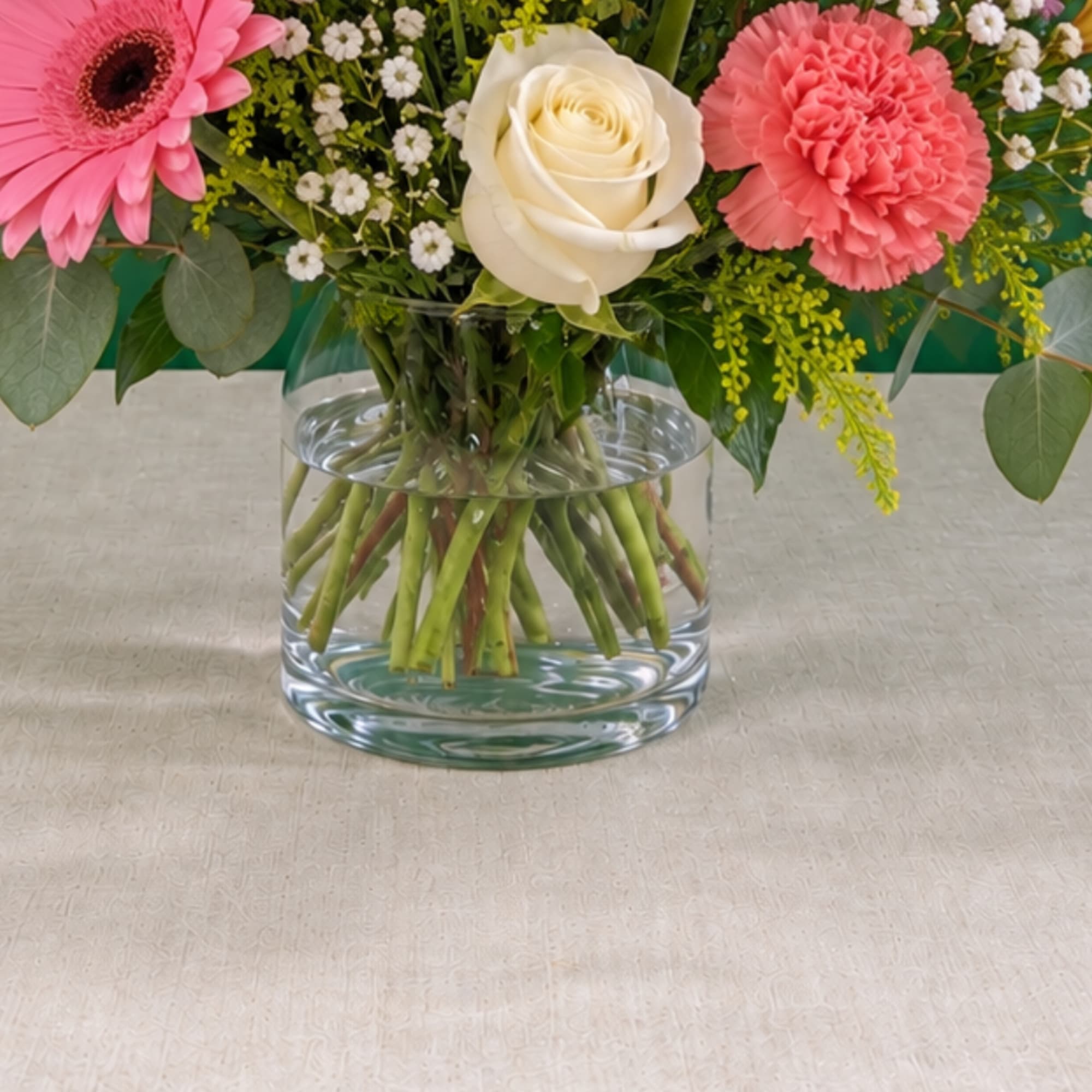 Pink and white flowers arranged in a clear glass vase