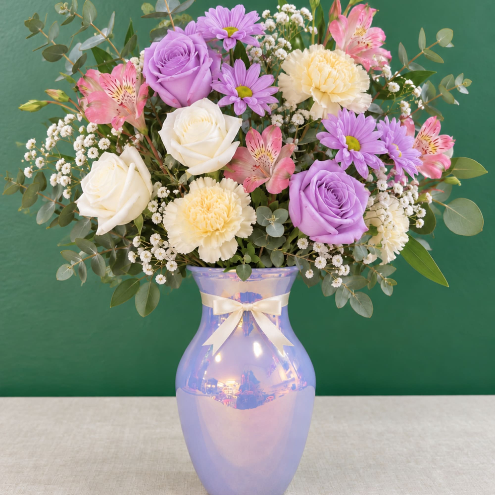 Lavender and white roses with pink flowers in a purple vase
