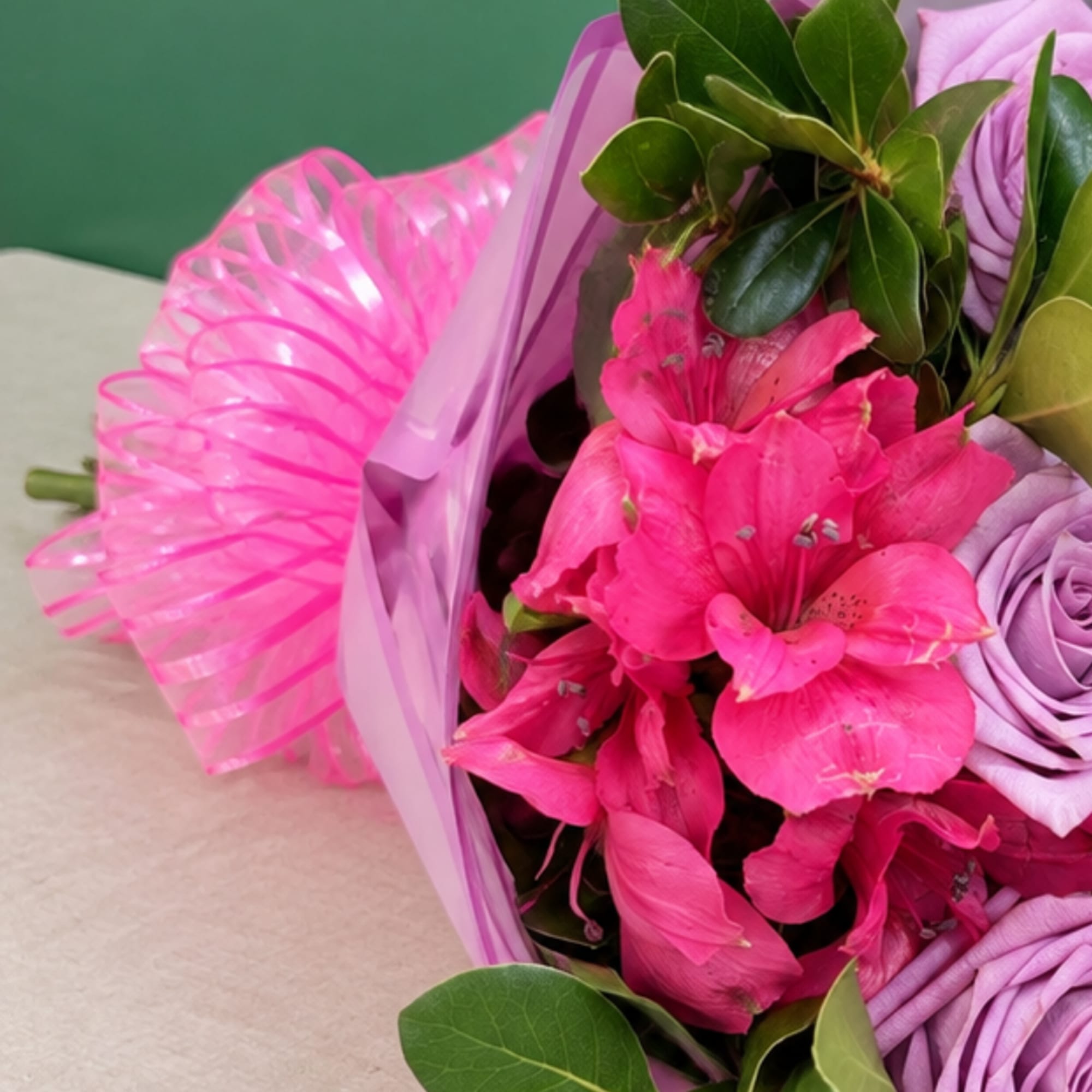 Pink and lavender bouquet with bright pink flowers and ribbon wrap