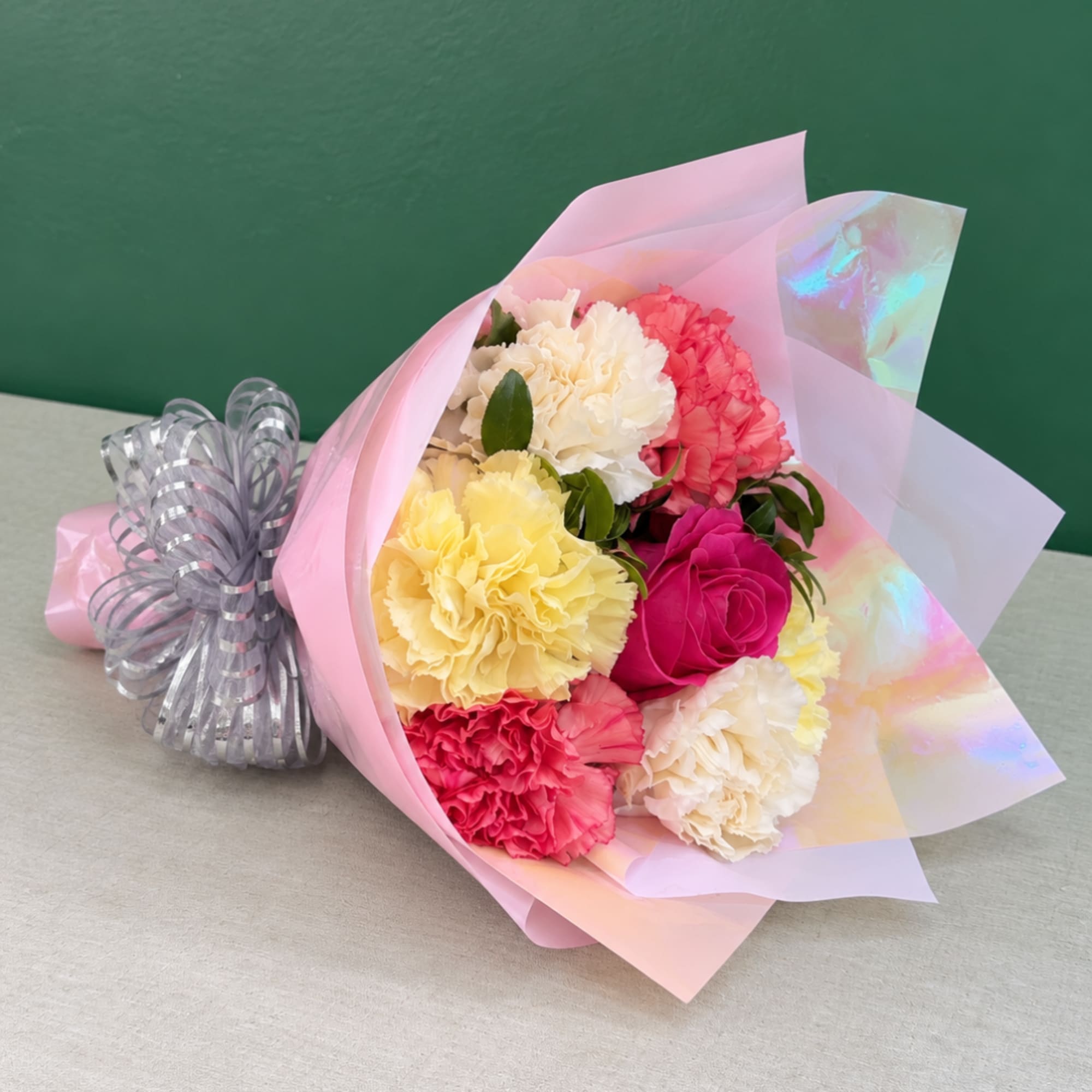 Bouquet of multicolored carnations wrapped in pink paper
