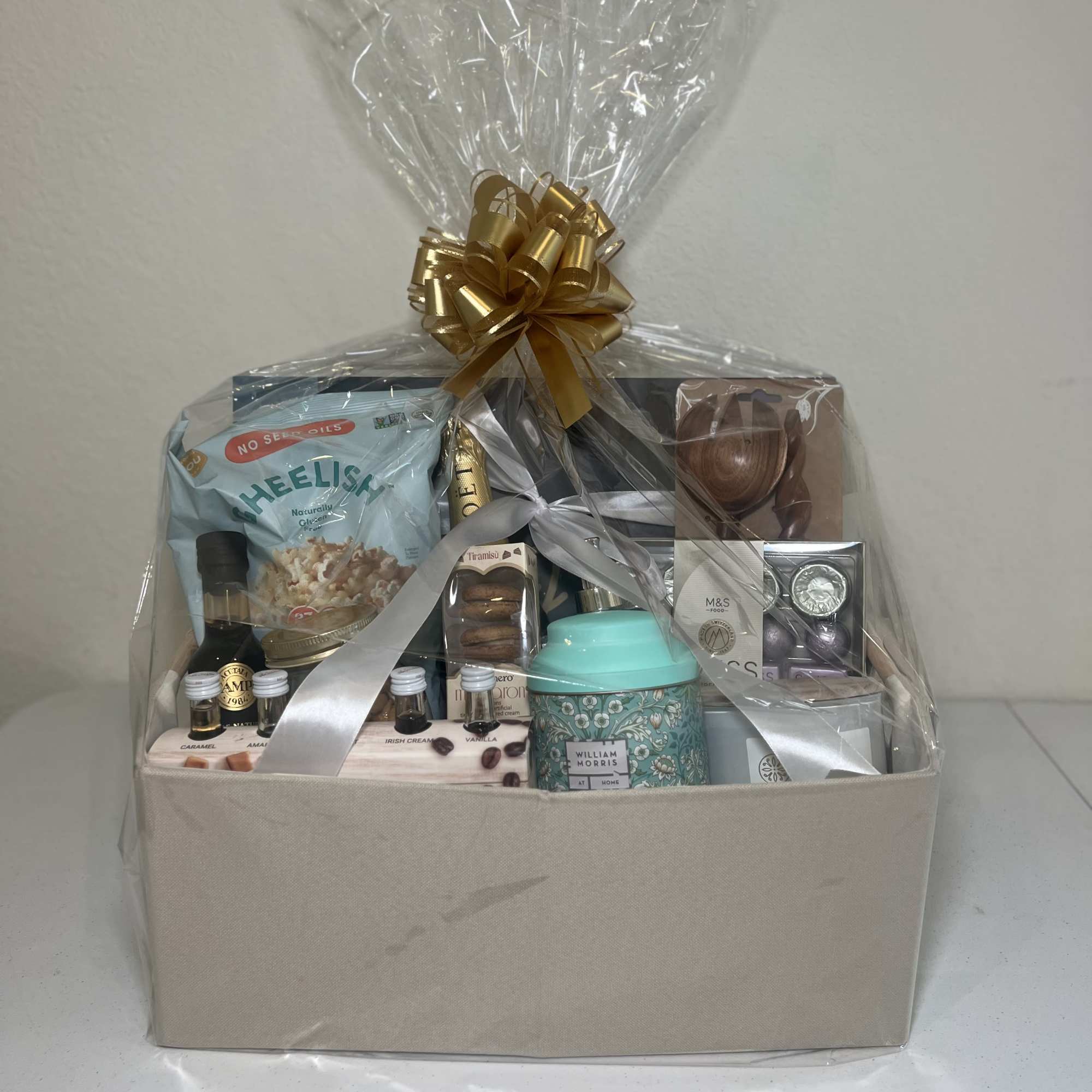 Gift basket with assorted snacks and candles wrapped in clear cellophane