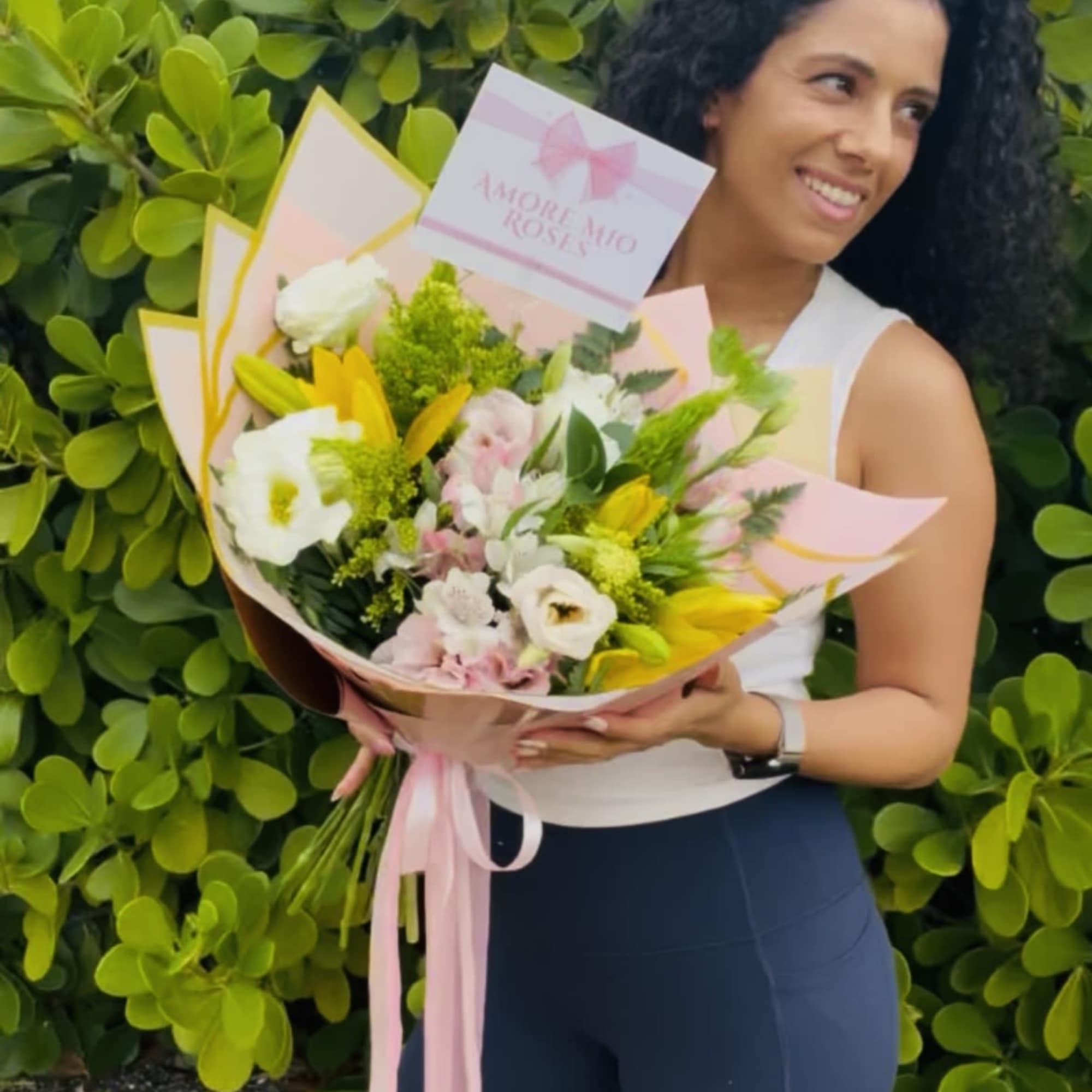 Woman holding a pastel bouquet with white and yellow flowers