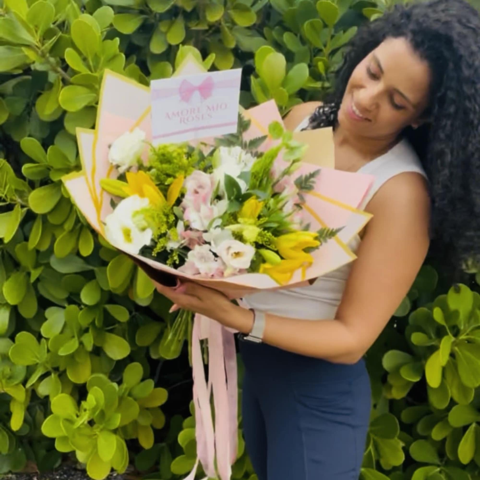 Woman holding a pastel bouquet with yellow and white flowers