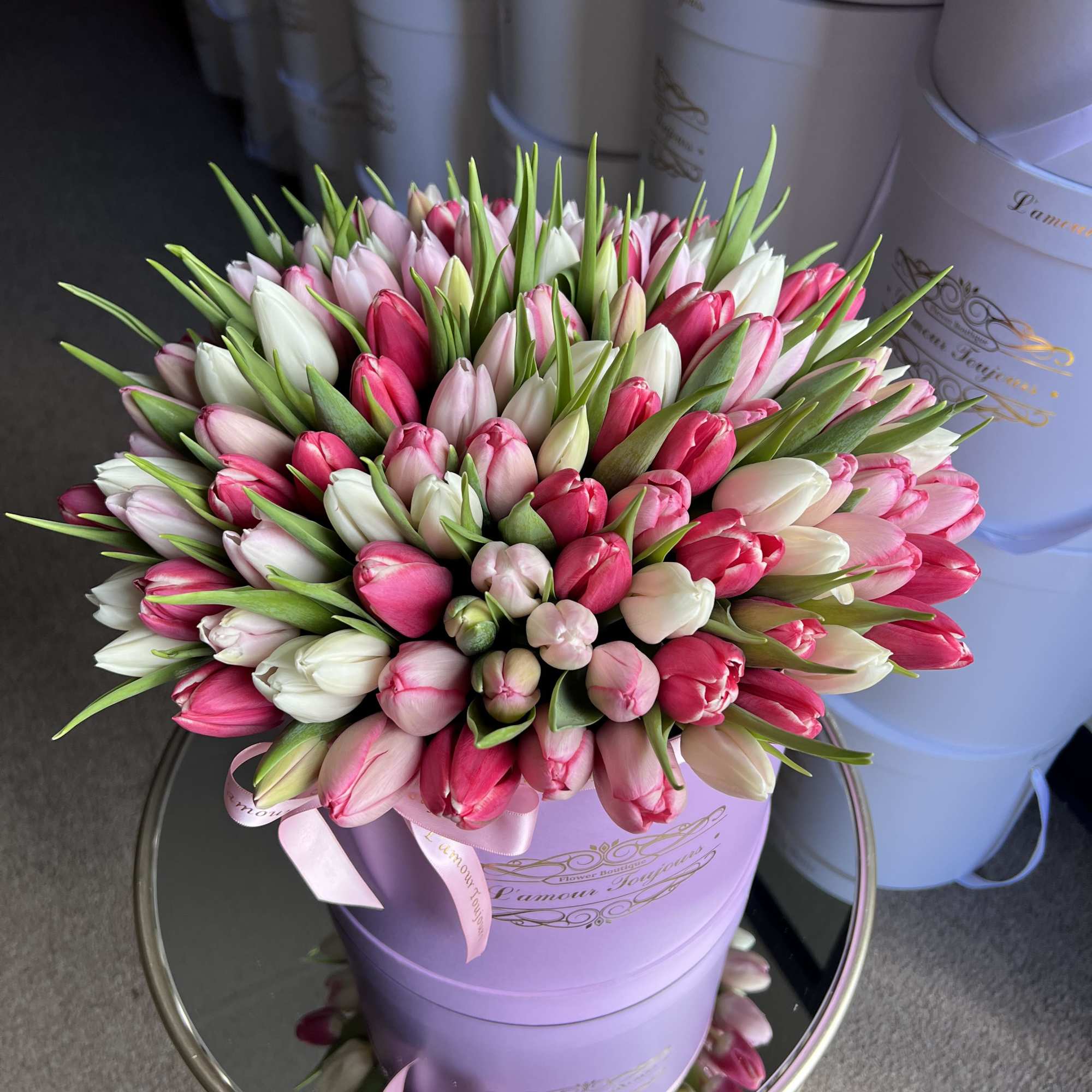 Pink and white tulips arranged in a lavender hat box
