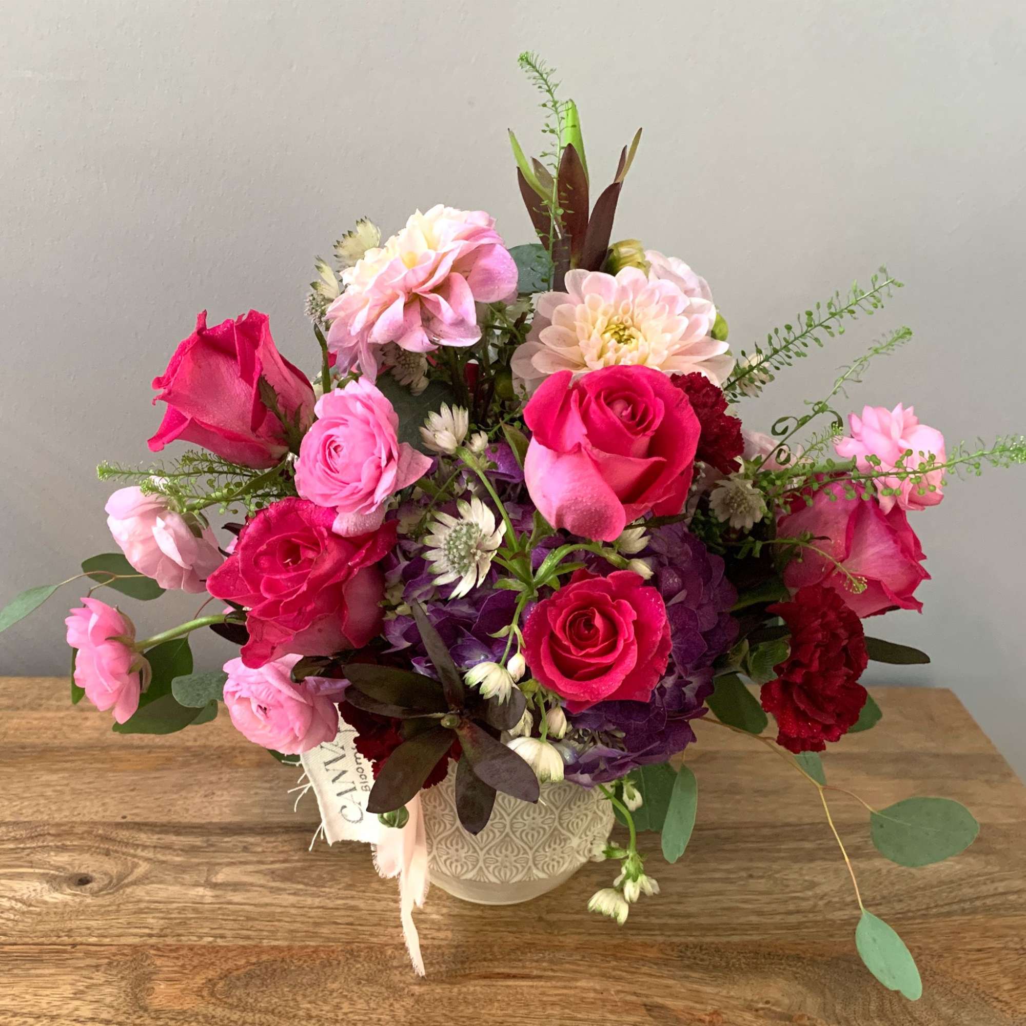 Pink and red rose bouquet in a patterned vase