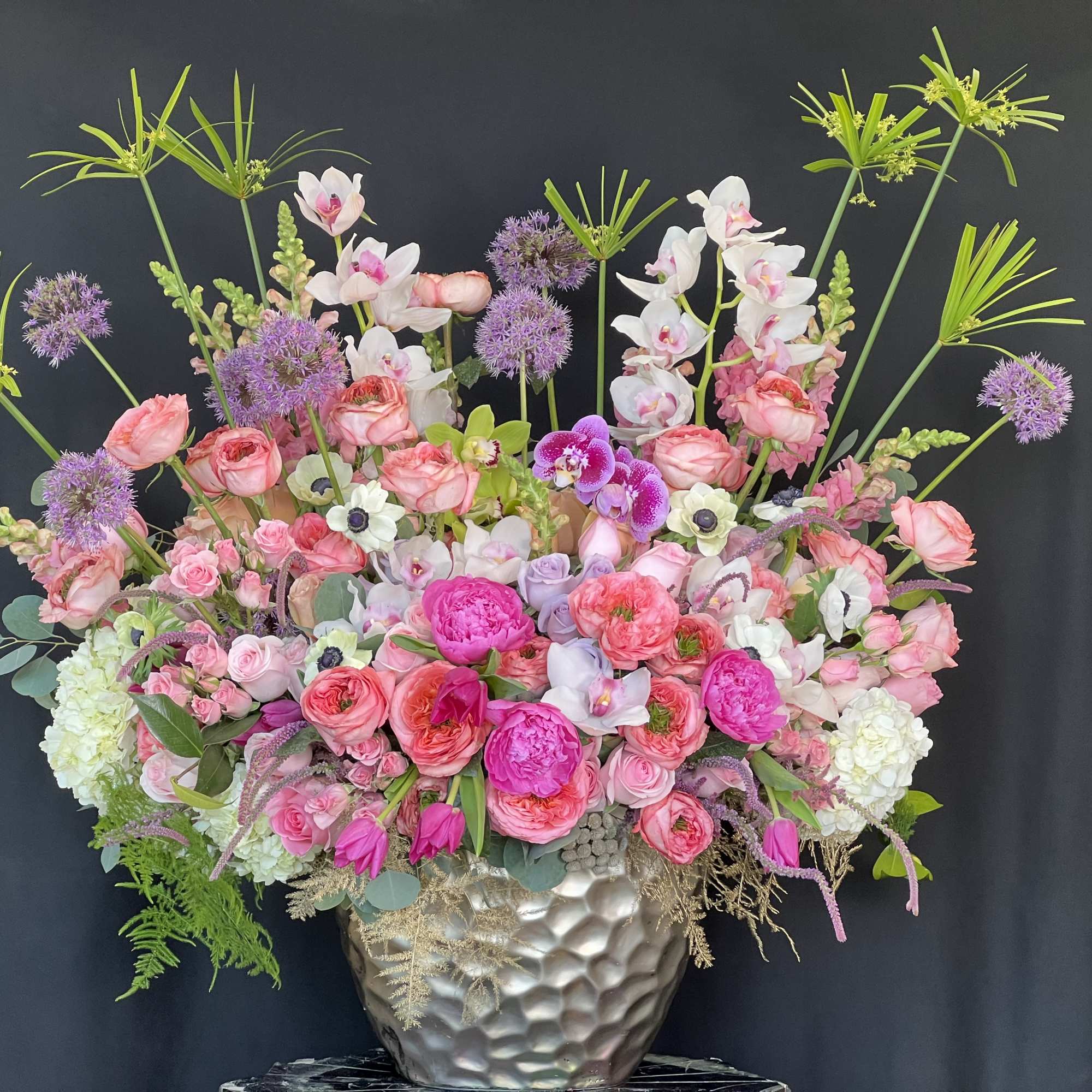 Large pink and white floral arrangement in a hammered silver vase