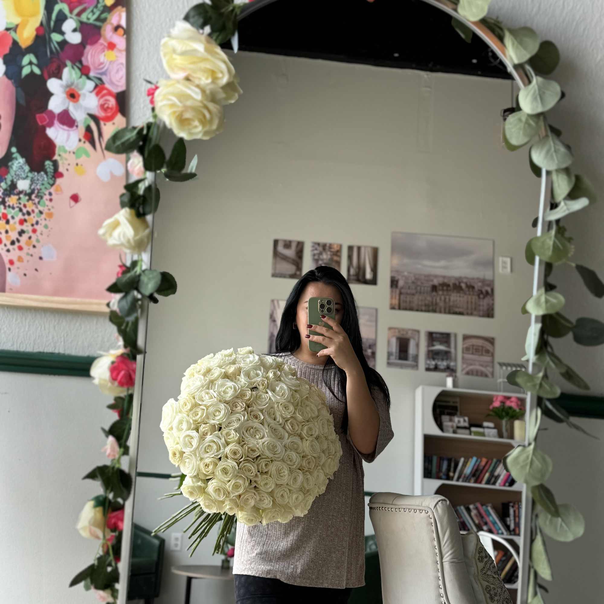 Woman holding a large bouquet of white roses in front of a mirror