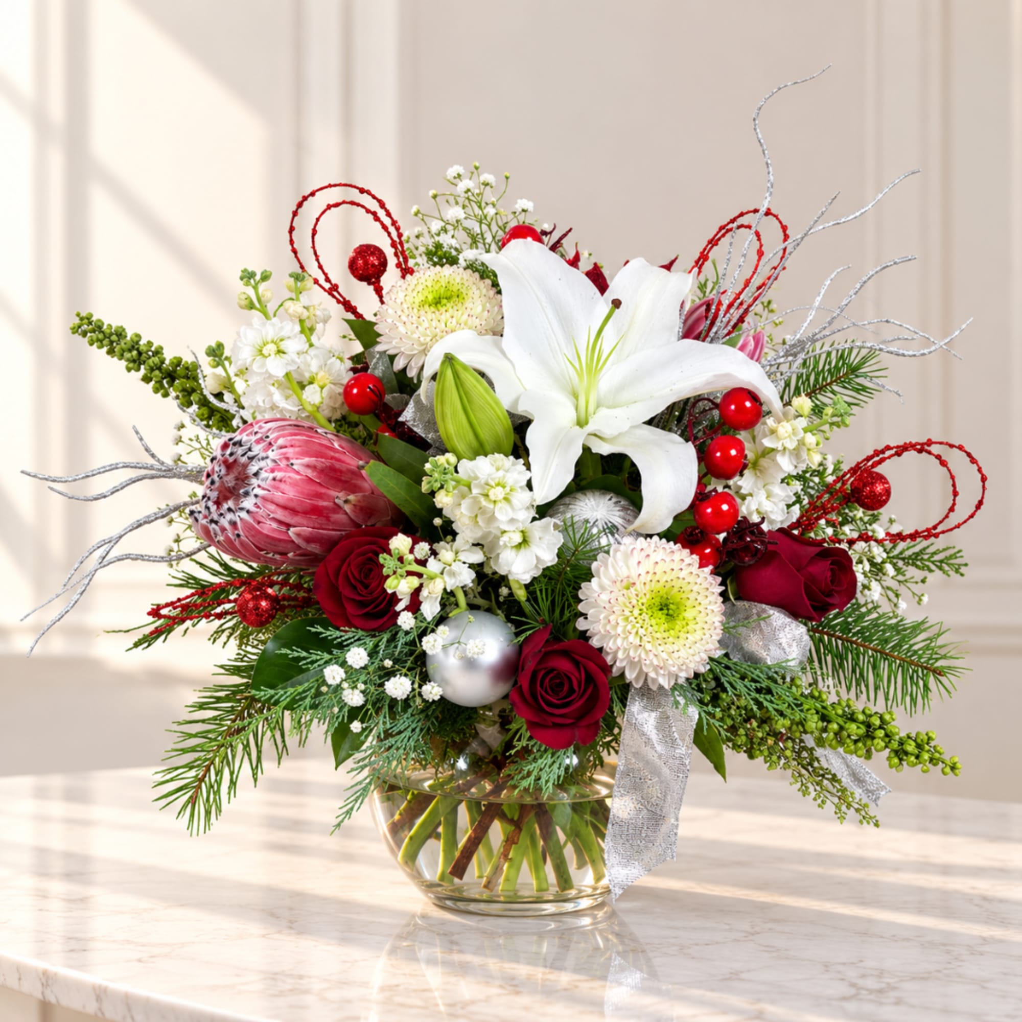 Holiday bouquet with white lilies, red roses, and a glass vase