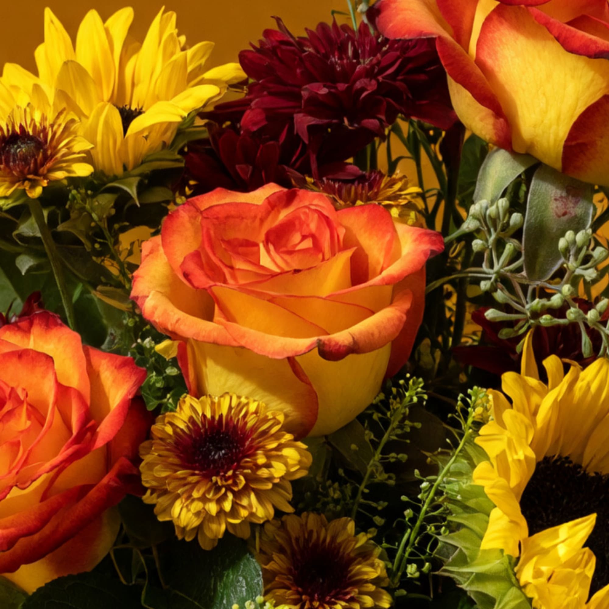 Bouquet of orange roses and yellow sunflowers with dark red mums