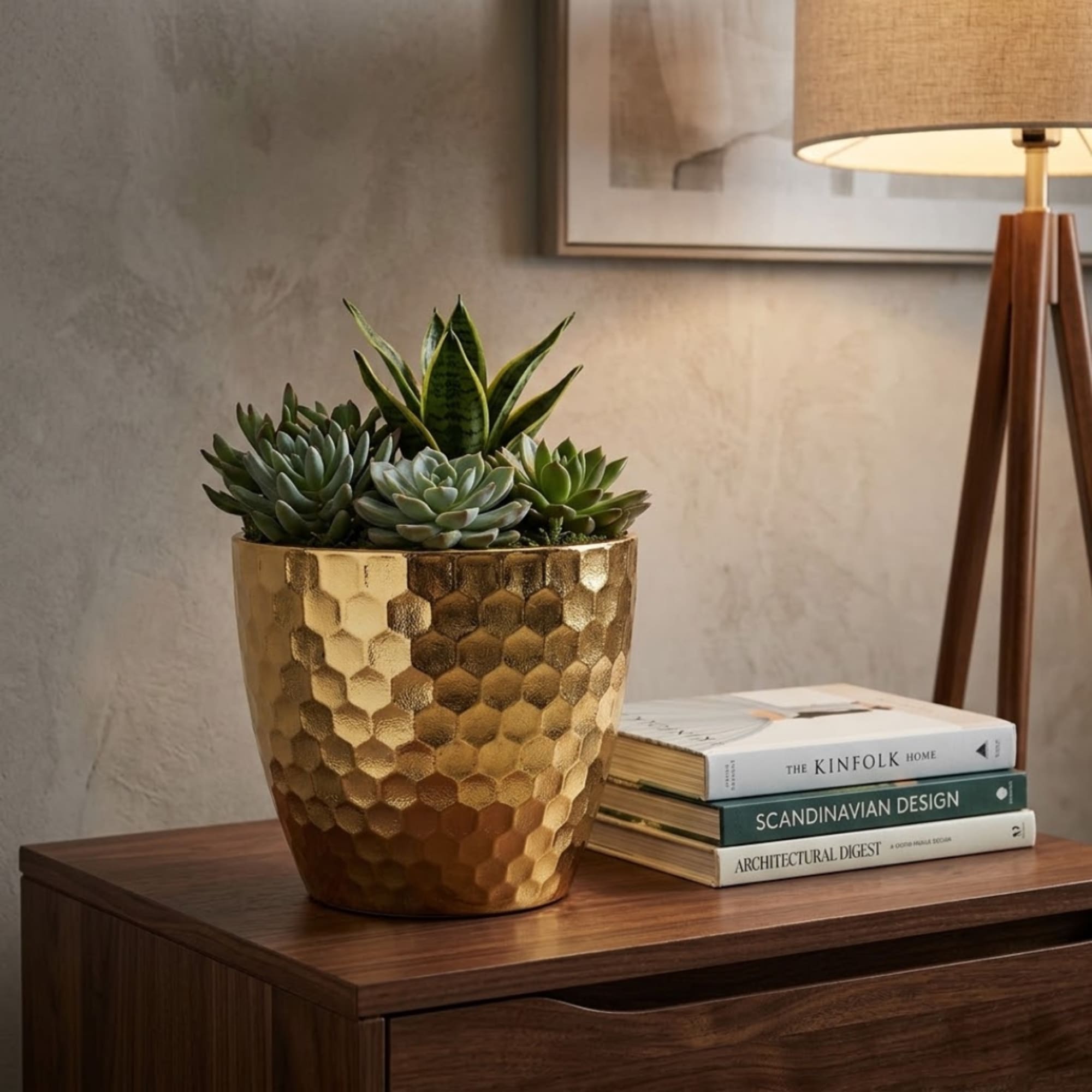 Succulent arrangement in a gold textured pot on a wooden table