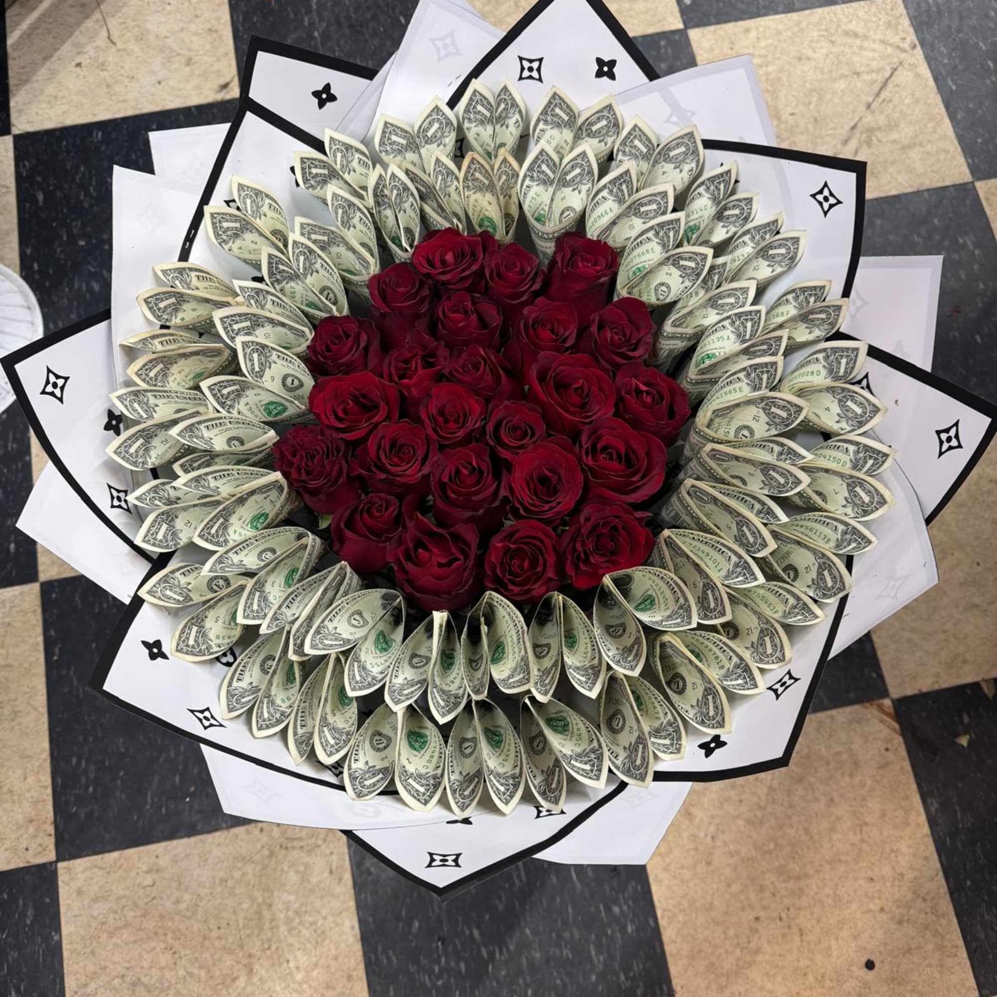 Bouquet of red roses surrounded by folded dollar bills