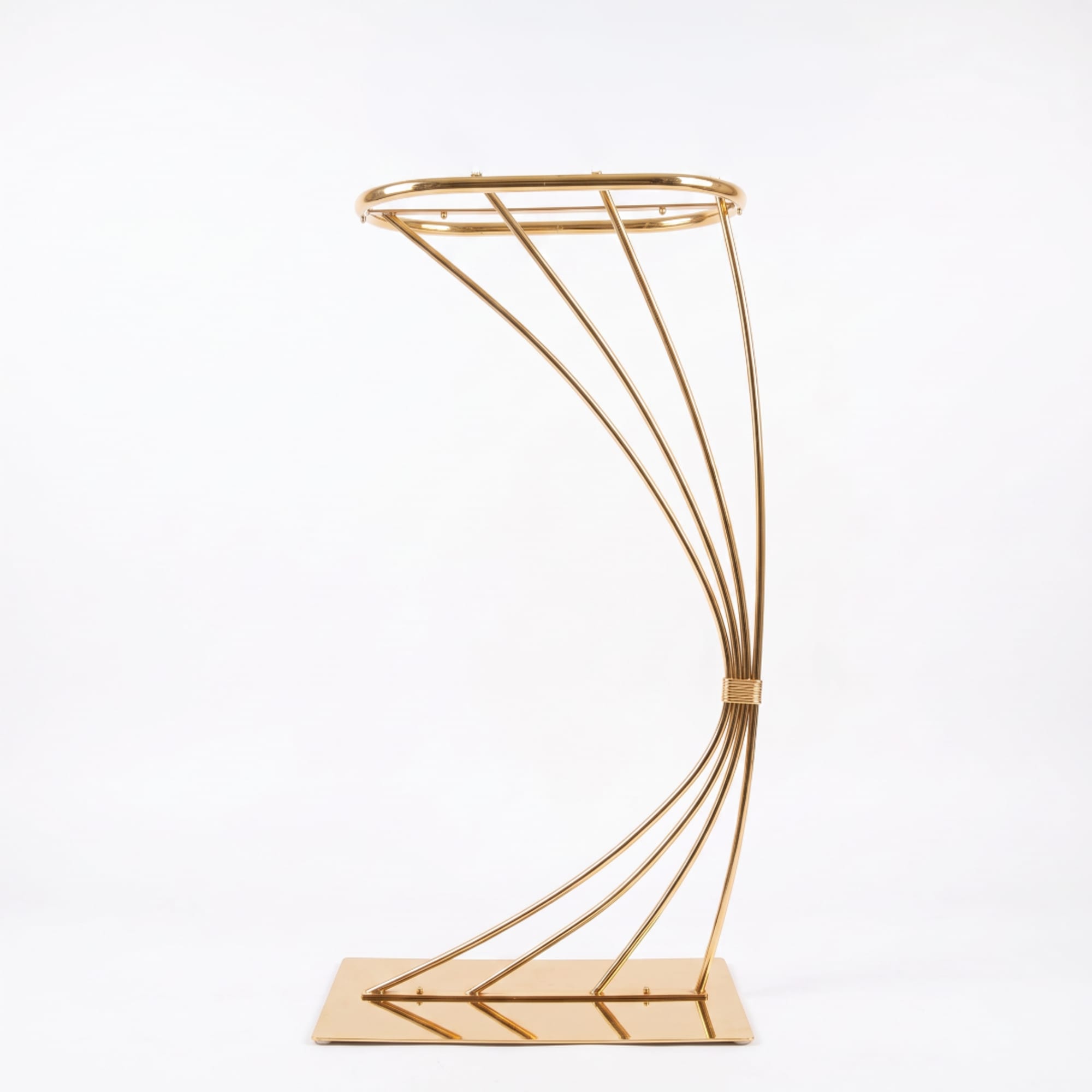 Gold metal floral stand with curved frame on a rectangular base