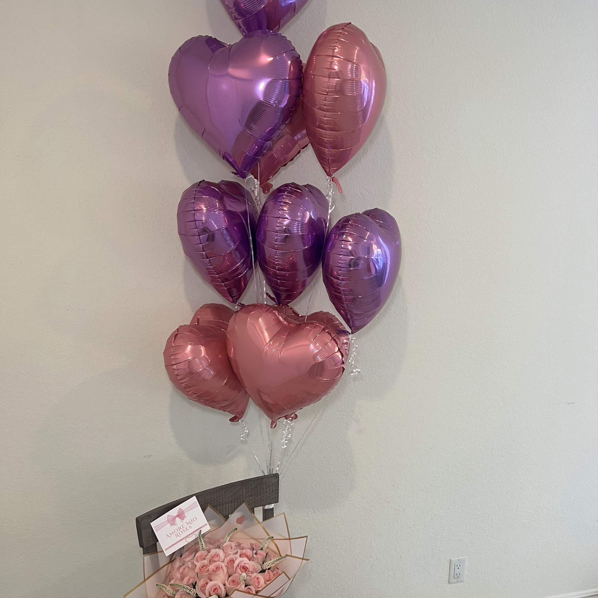 Pink rose bouquet with heart-shaped balloons above it
