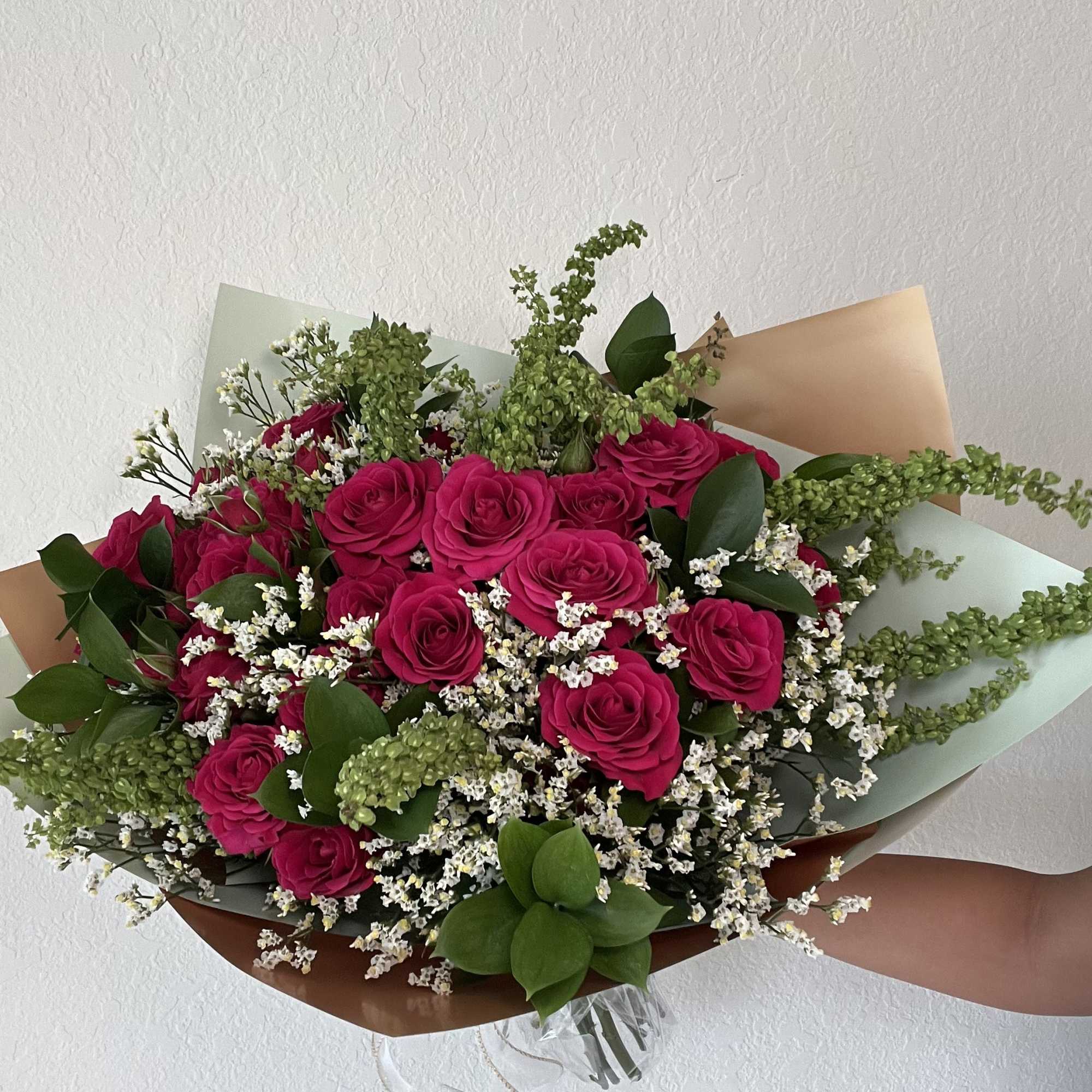 Bouquet of hot pink roses with white filler flowers and greenery