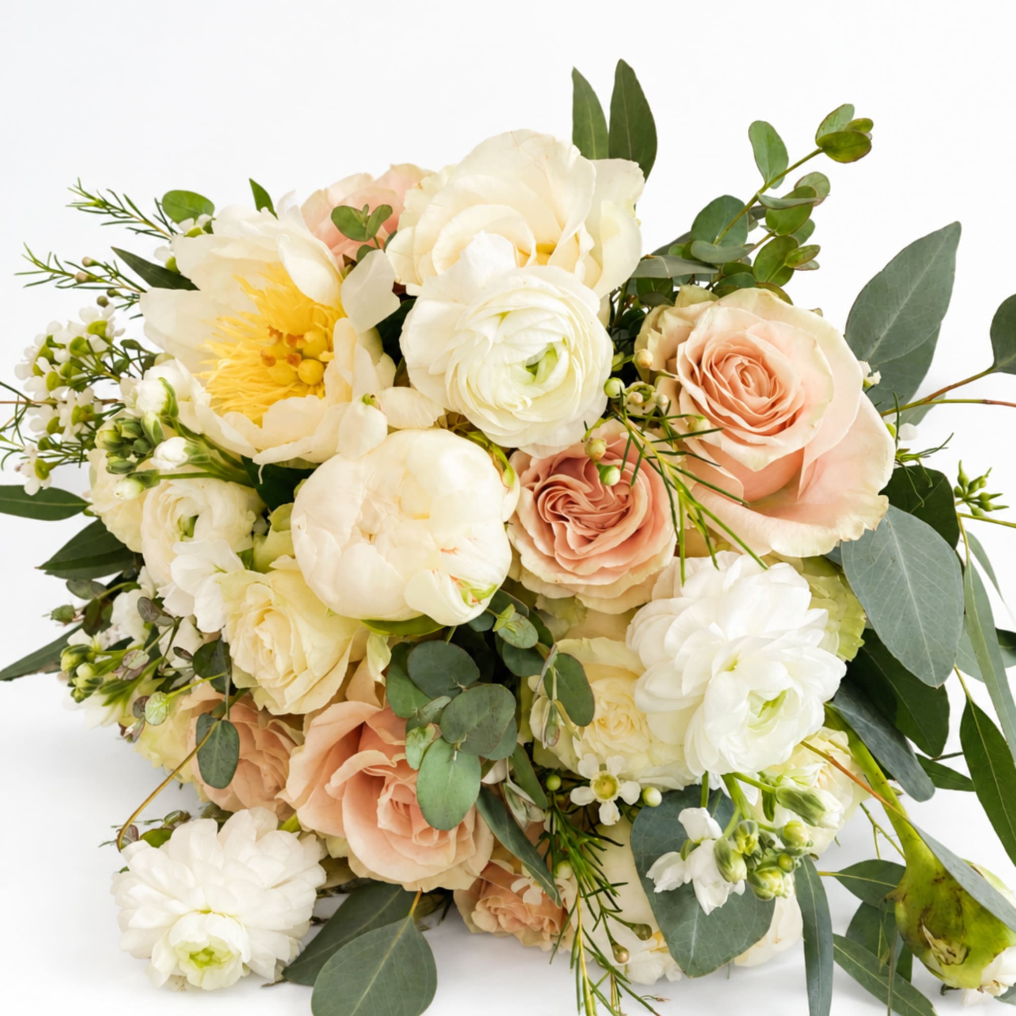 Bouquet of cream and peach roses with white blooms and greenery