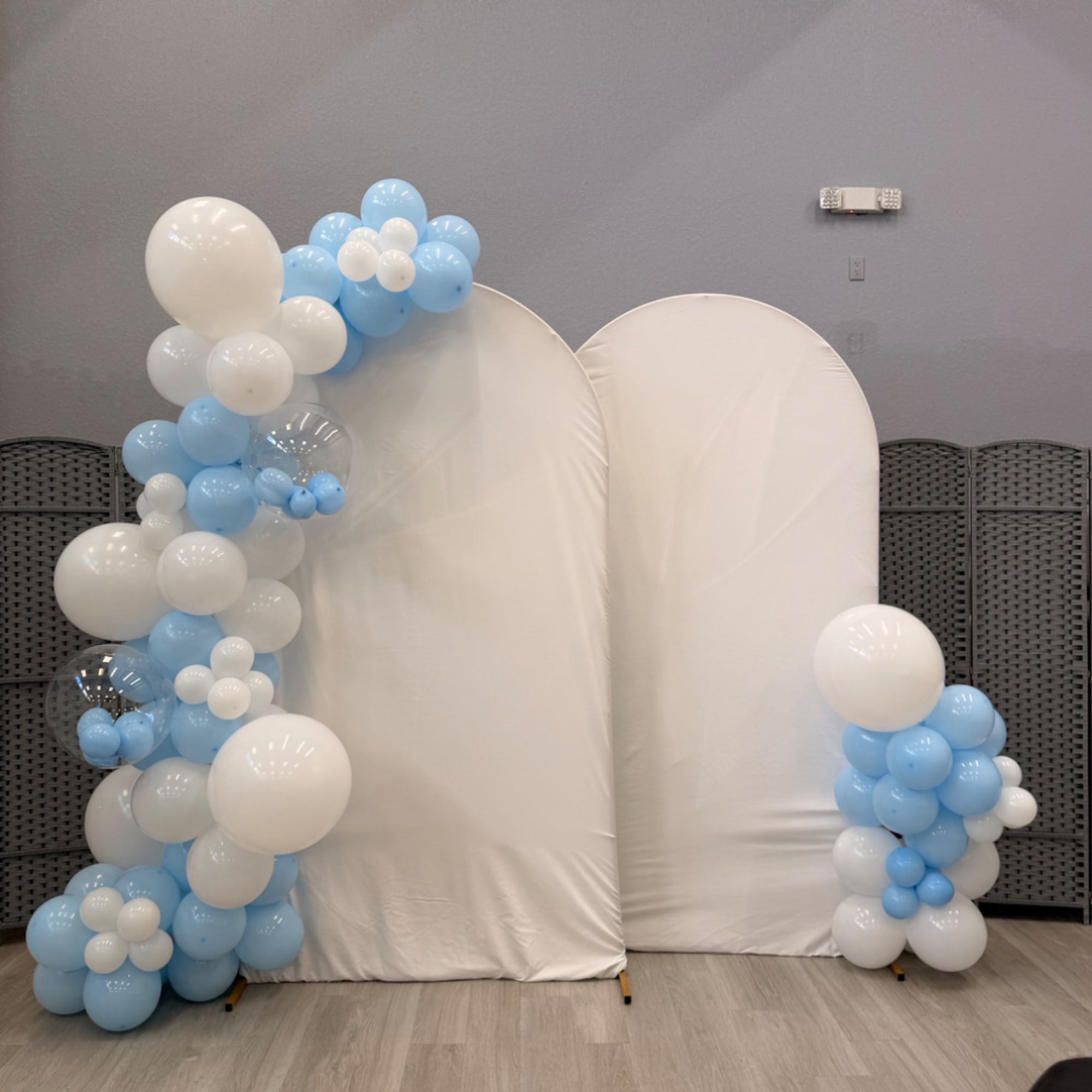 Blue and white balloon arch framing two white backdrop panels