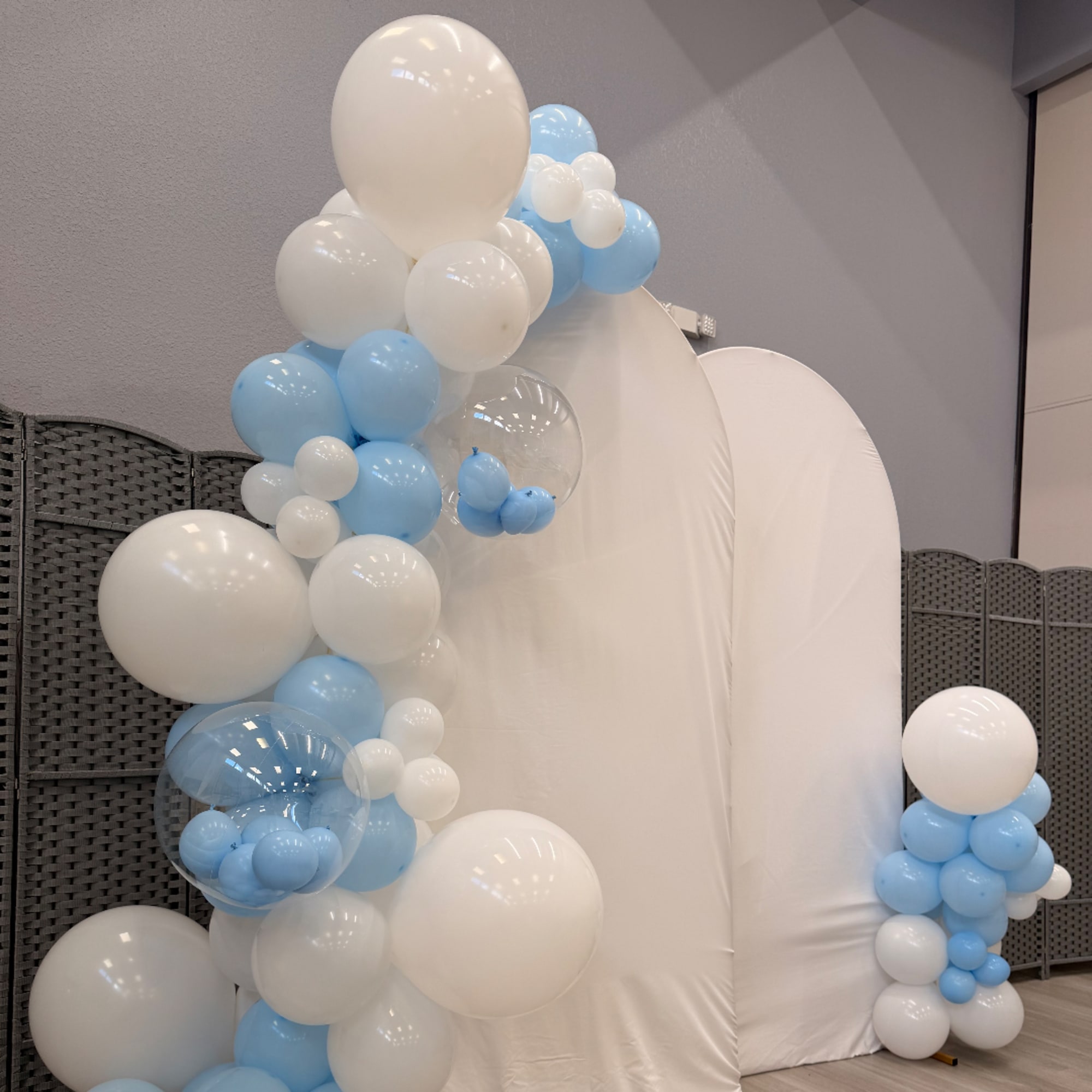 Blue and white balloon display around a large white backdrop